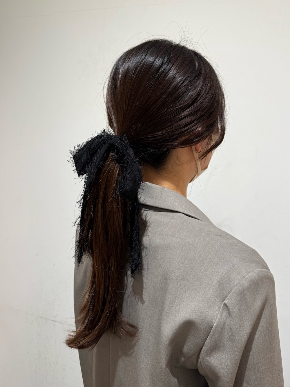 ブラック系のヘアゴムを着用したレディースの冬コーディネートの2枚目の写真