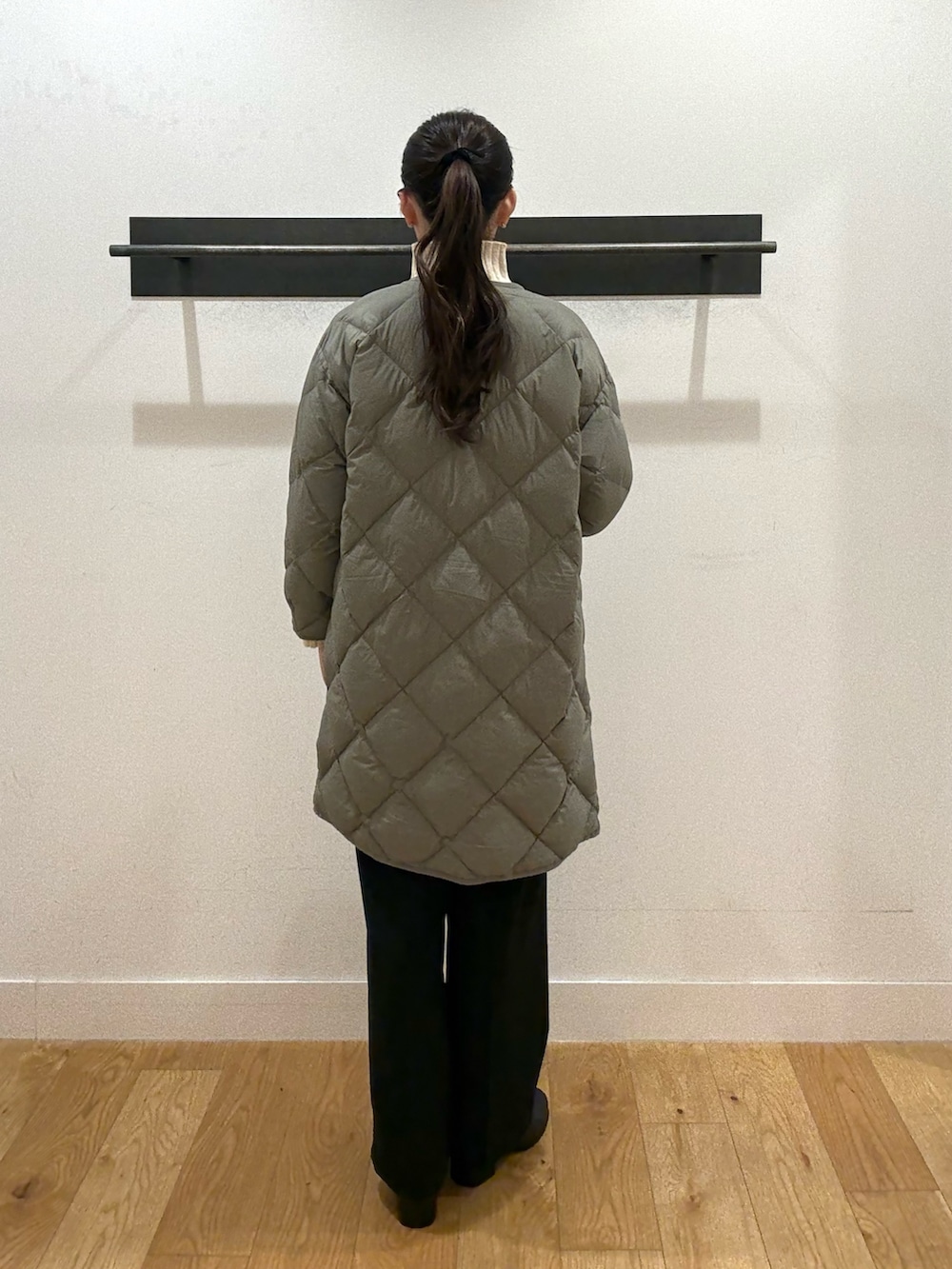 ホワイト系のニット/セーター、ホワイト系のニット/セーター、グリーン系のダウンジャケット/コートを着用したレディースの冬コーディネートの2枚目の写真