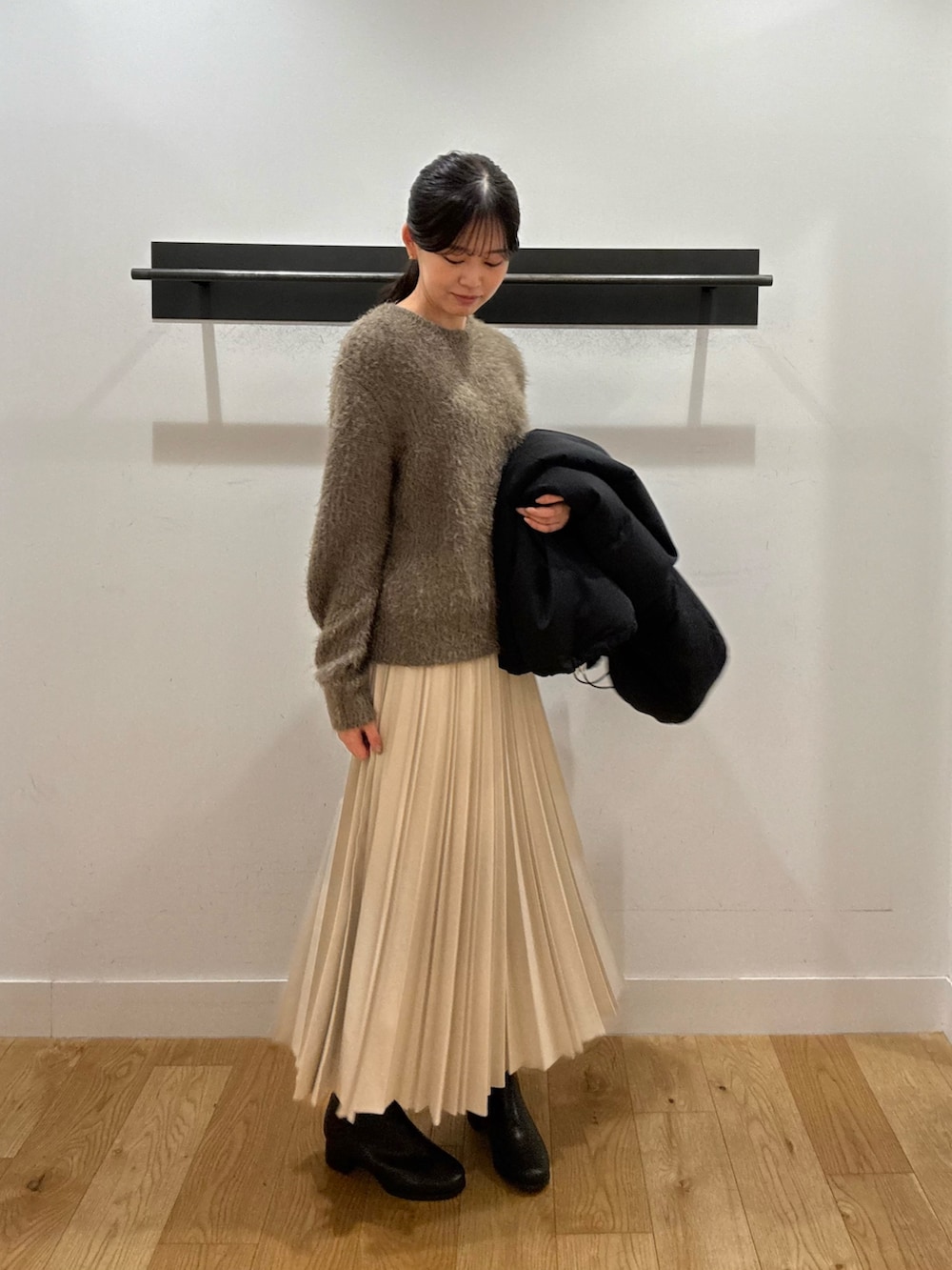 ブラック系のダウンジャケット/コート、グリーン系のニット/セーター、グリーン系のニット/セーターを着用したレディースの冬コーディネートの4枚目の写真