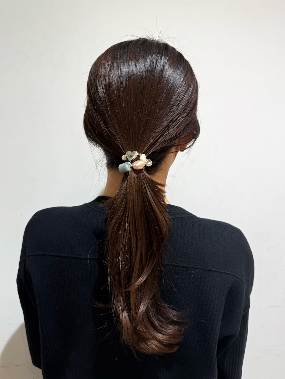 ベージュ系のヘアゴムを着用したレディースの冬コーディネートの2枚目の写真