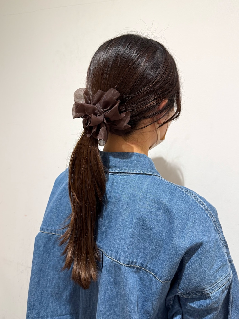 ブラウン系のヘアゴムを着用したレディースの冬コーディネートの2枚目の写真