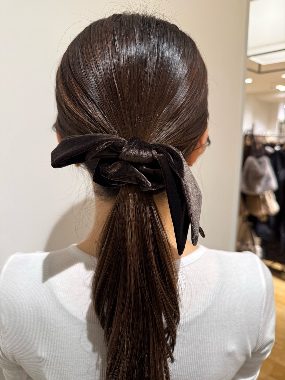 ブラウン系のシュシュを着用したレディースの秋コーディネートの2枚目の写真