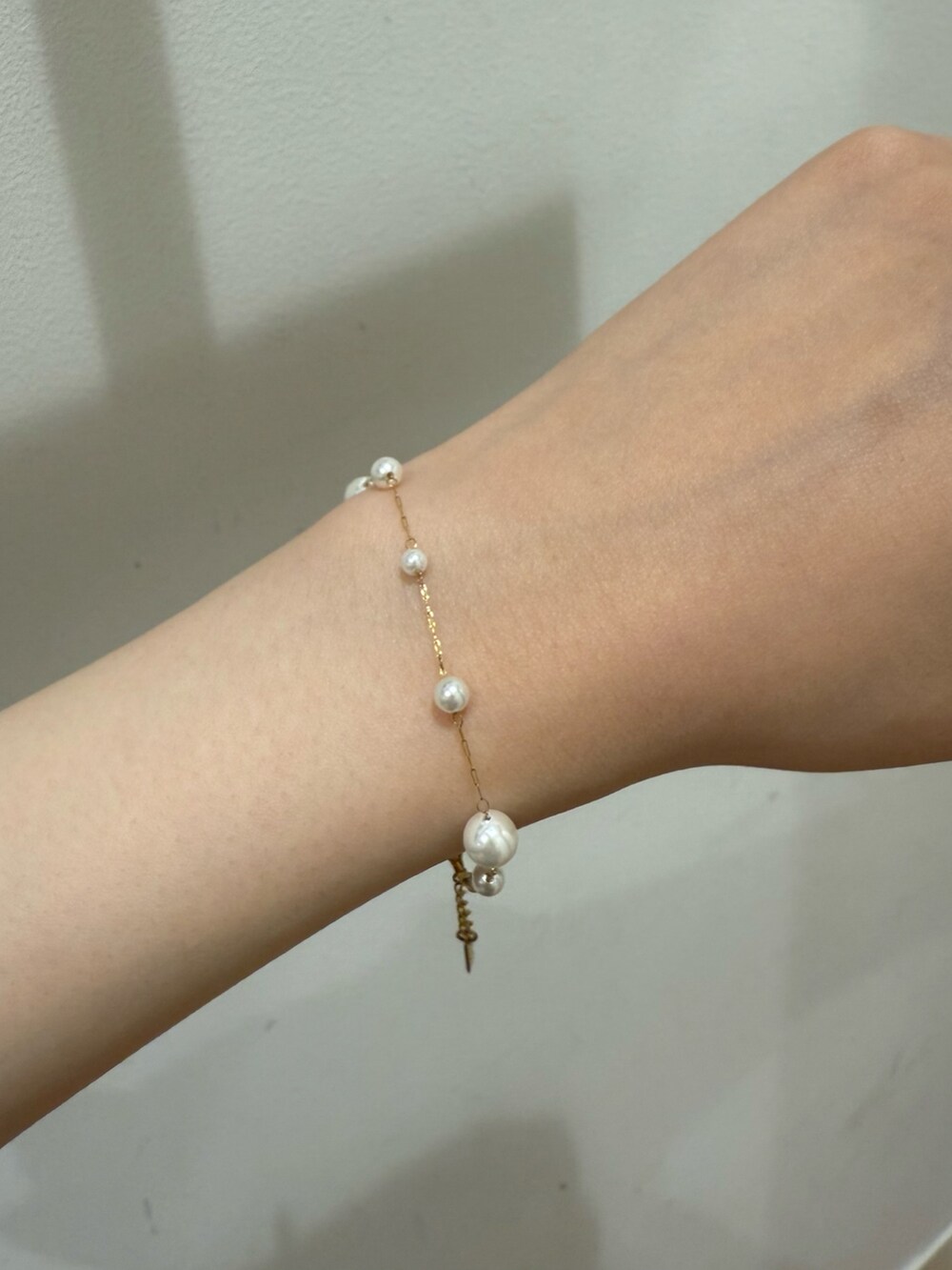 ゴールド系のブレスレットを着用したレディースの春コーディネートの2枚目の写真