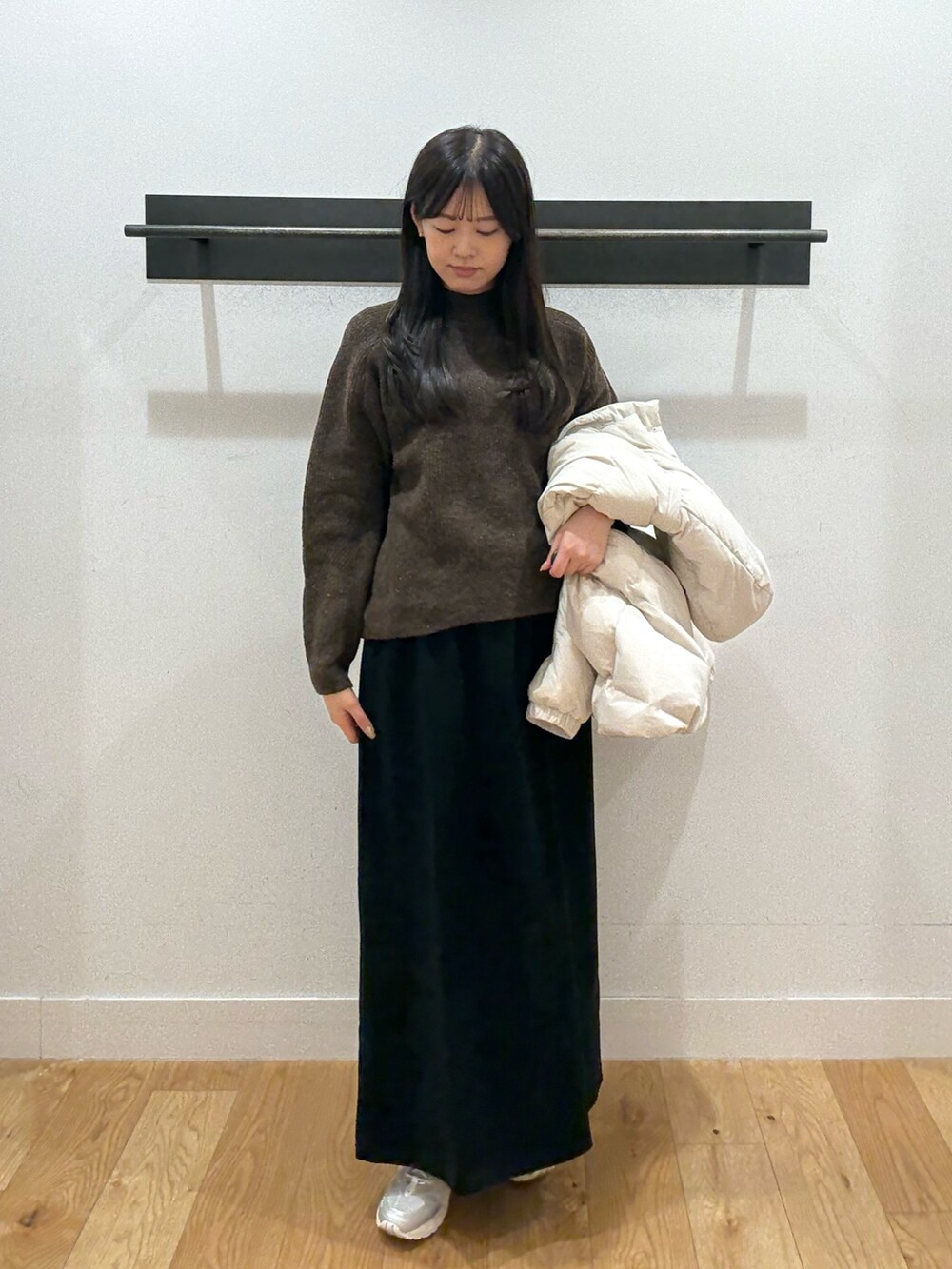 ホワイト系のダウンジャケット/コート、ホワイト系のダウンジャケット/コート、ブラウン系のニット/セーターを着用したレディースの冬コーディネートの3枚目の写真