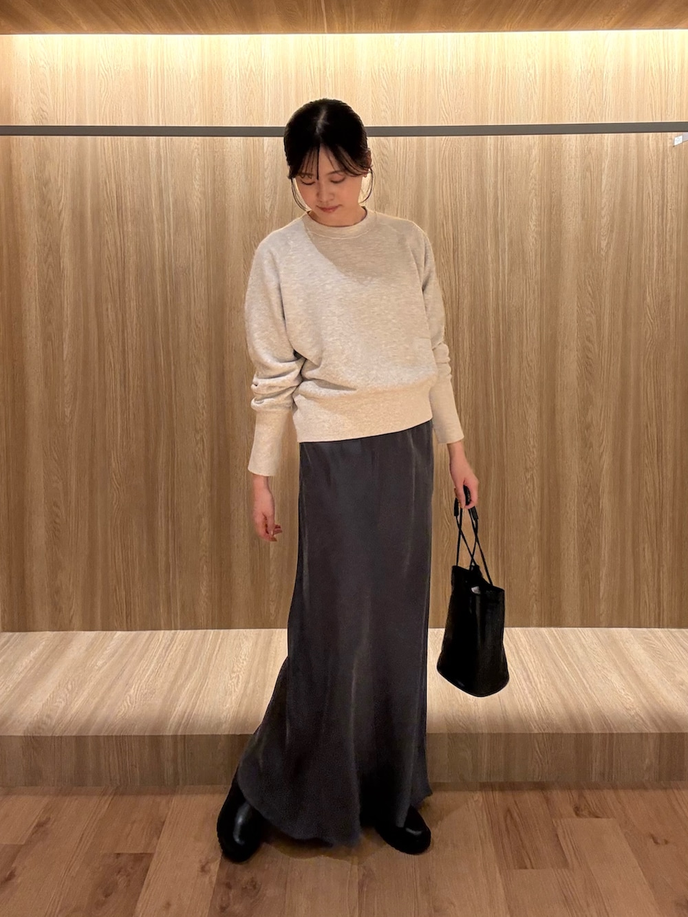 グレー系のTシャツ/カットソー、グレー系のスカート、ブラック系のショルダーバッグを着用したレディースの冬コーディネートの4枚目の写真