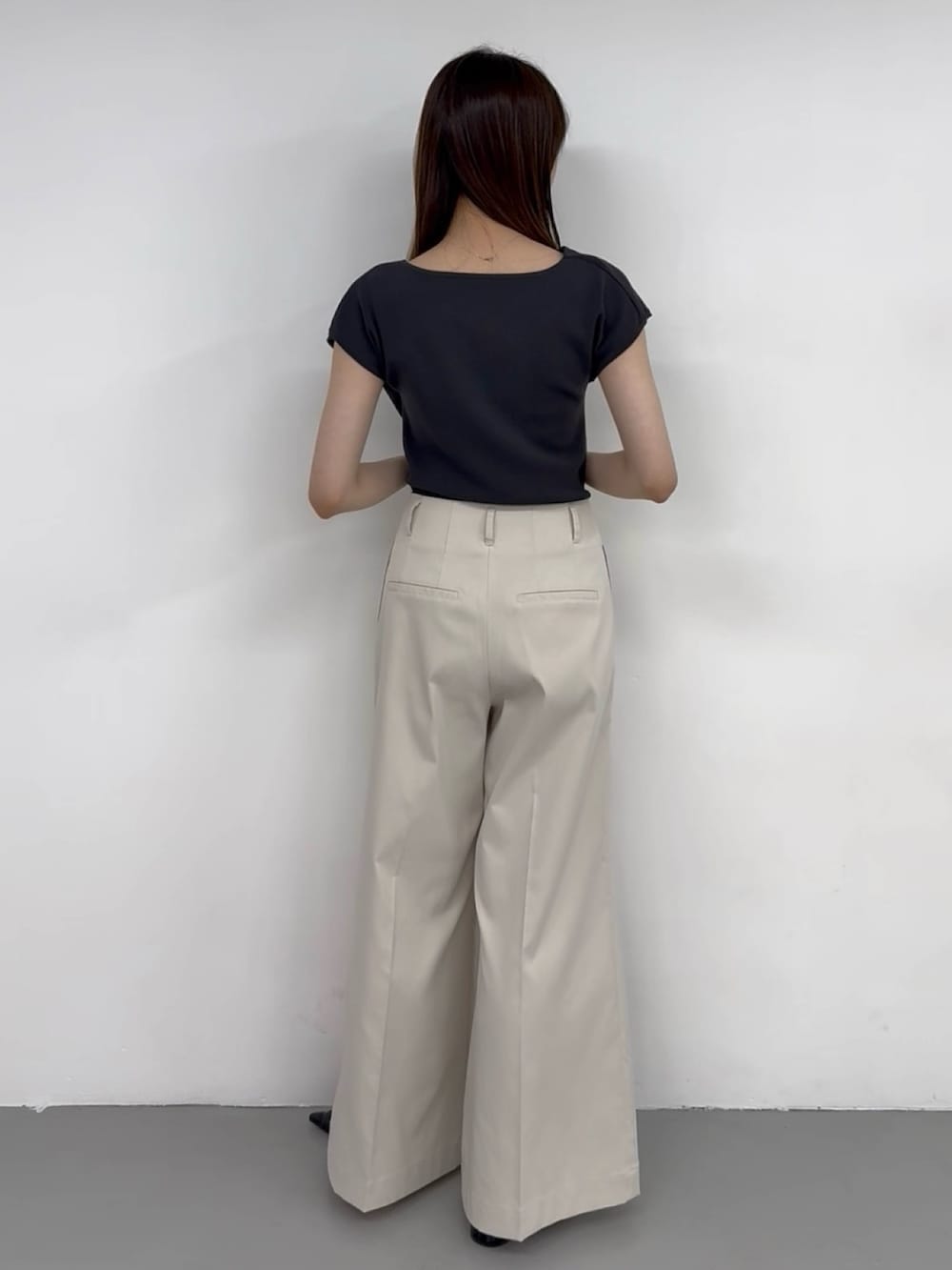 グレー系のニット/セーター、ホワイト系のチノパンツ、ホワイト系のチノパンツを着用したレディースの夏コーディネートの3枚目の写真
