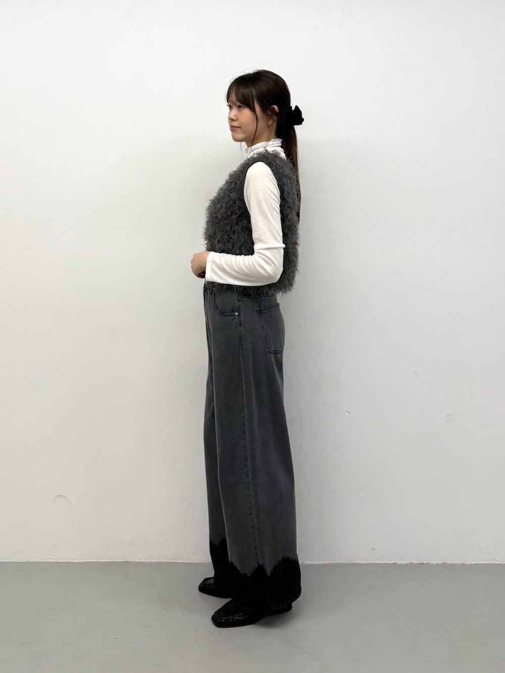 グレー系のベスト、グレー系のベスト、グレー系のデニムパンツを着用したレディースの秋コーディネートの2枚目の写真