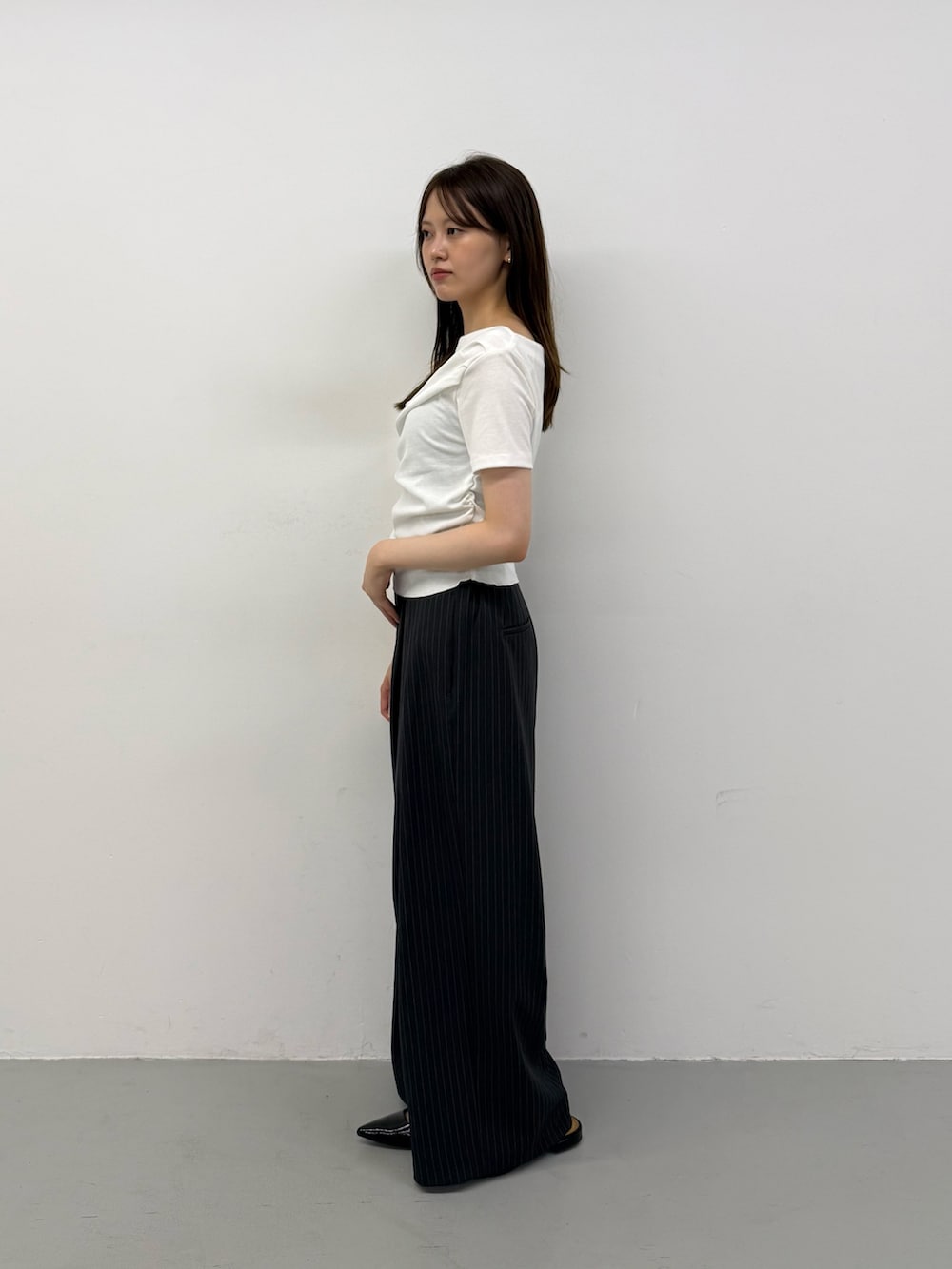 ホワイト系のTシャツ/カットソー、ホワイト系のTシャツ/カットソー、グレー系のスラックスを着用したレディースの夏コーディネートの2枚目の写真