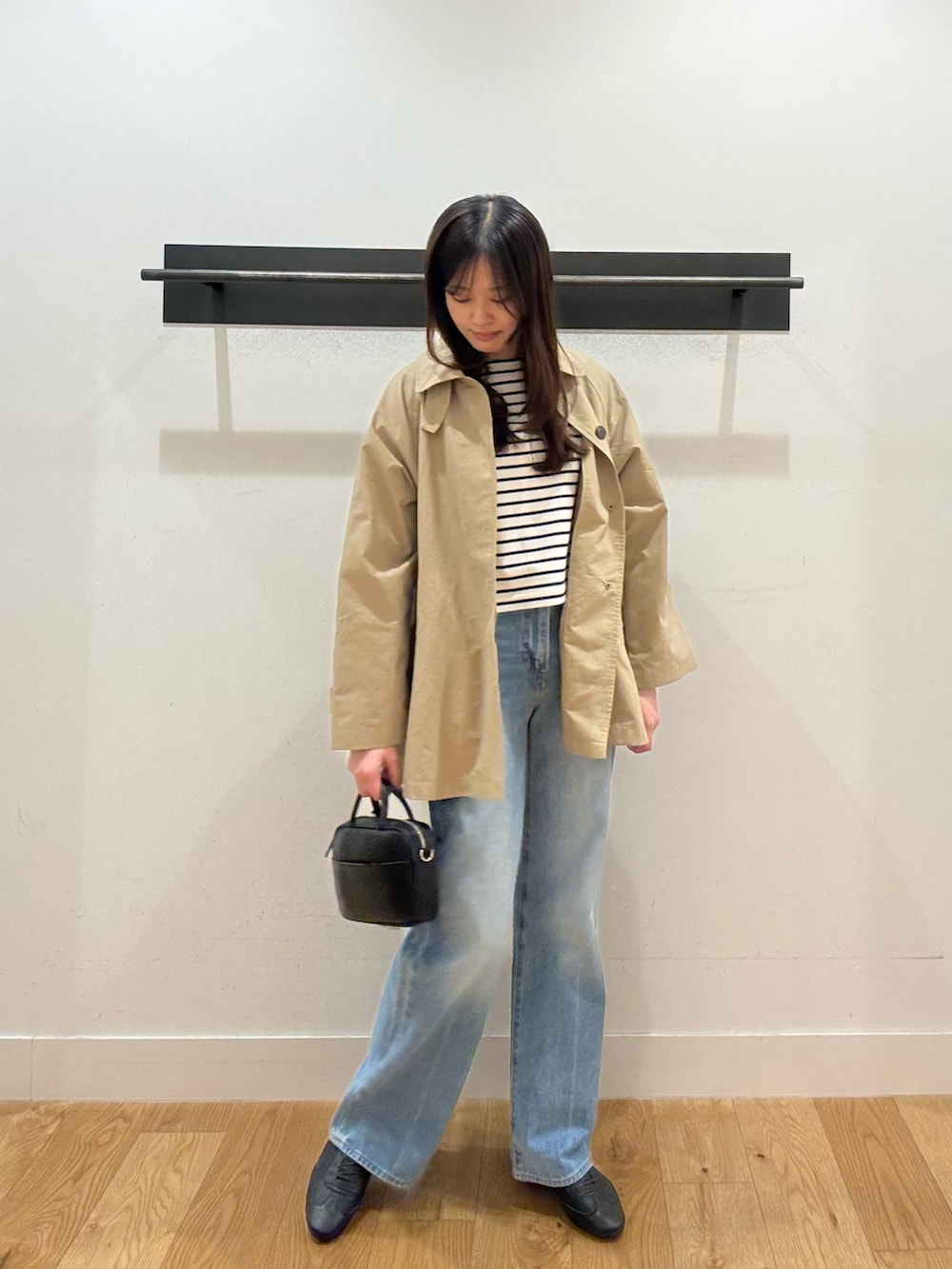 ベージュ系のステンカラーコート、ベージュ系のステンカラーコート、ブラック系のTシャツ/カットソーを着用したレディースの春コーディネートの5枚目の写真