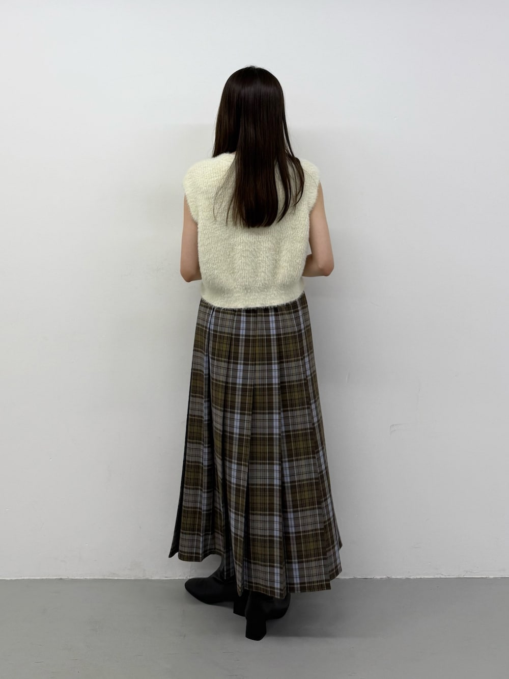 ホワイト系のニット/セーター、ホワイト系のニット/セーター、ブラック系のブーツを着用したレディースの秋コーディネートの3枚目の写真