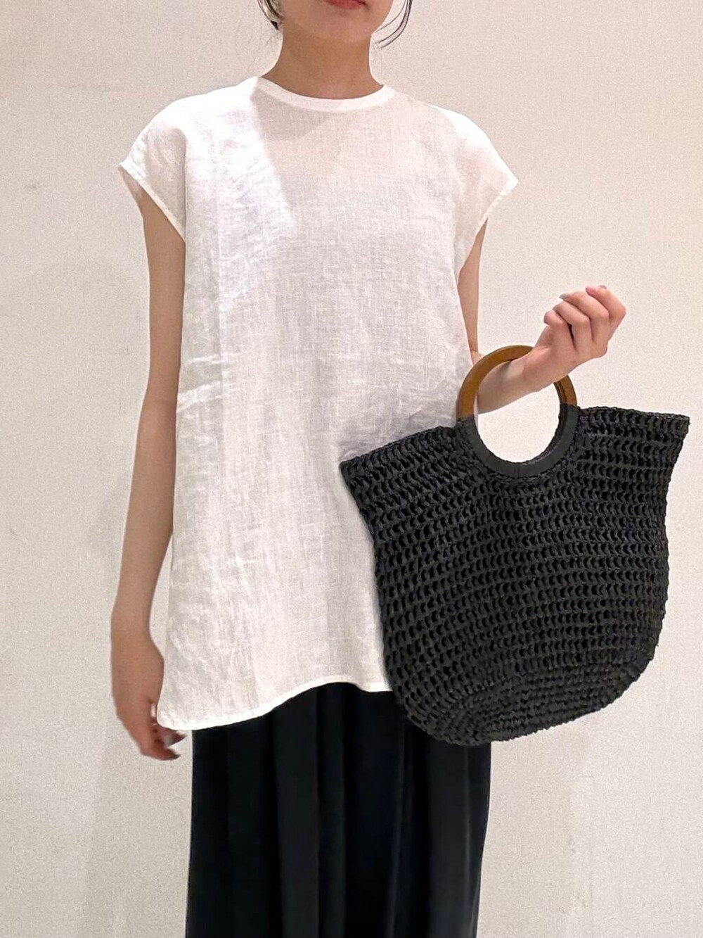 ブラック系のトートバッグ、ブラック系のバレエシューズ、ホワイト系のシャツ/ブラウスを着用したレディースの夏コーディネートの4枚目の写真