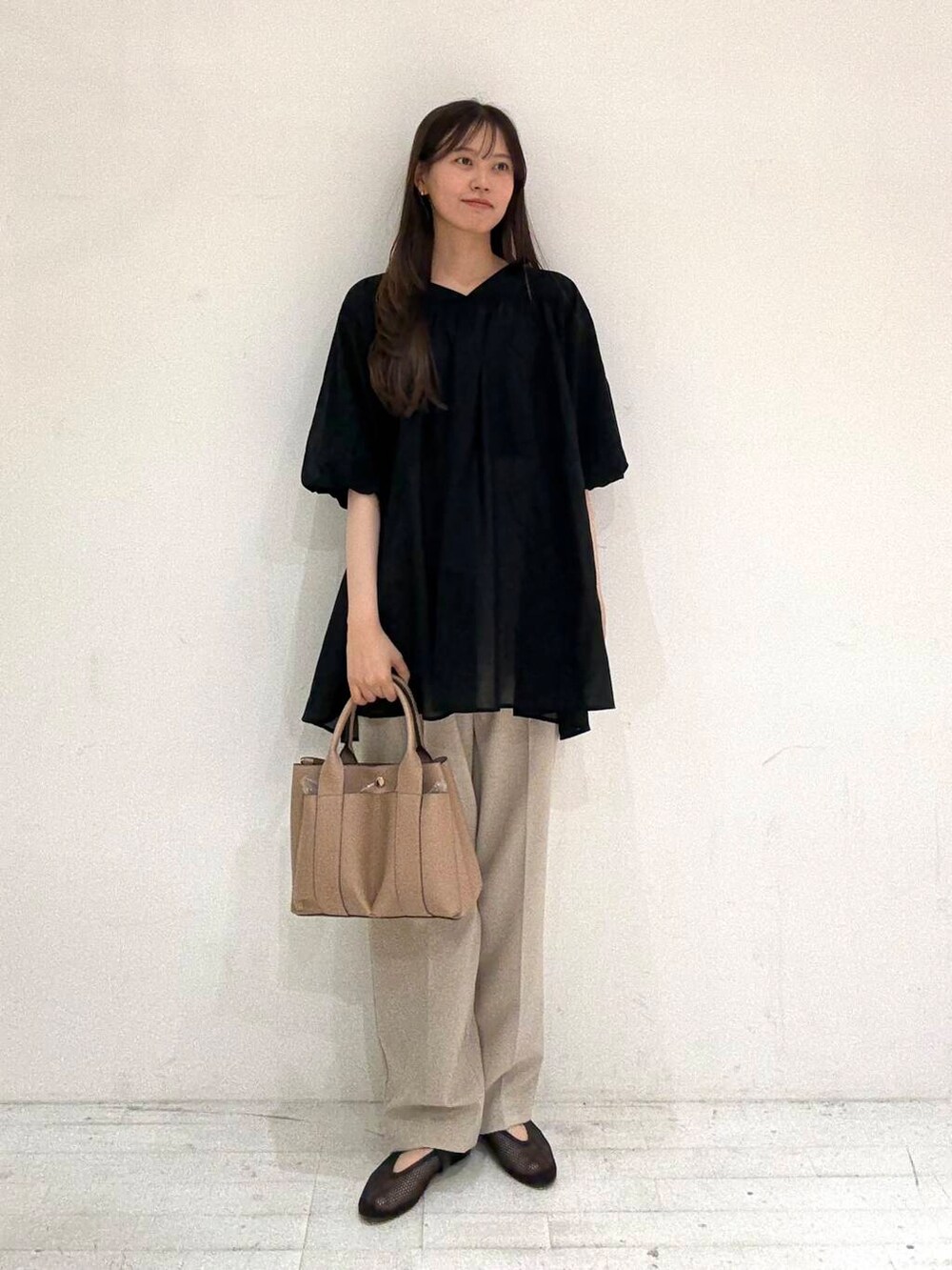 ベージュ系のトートバッグ、ベージュ系のその他パンツ、ブラック系のバレエシューズを着用したレディースの夏コーディネートの2枚目の写真