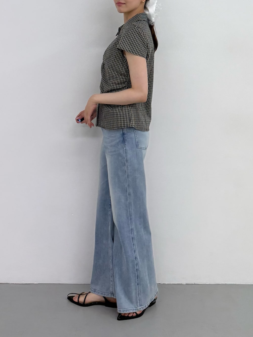 ブラック系のシャツ/ブラウス、ブルー系のデニムパンツ、ブルー系のデニムパンツを着用したレディースの夏コーディネートの2枚目の写真