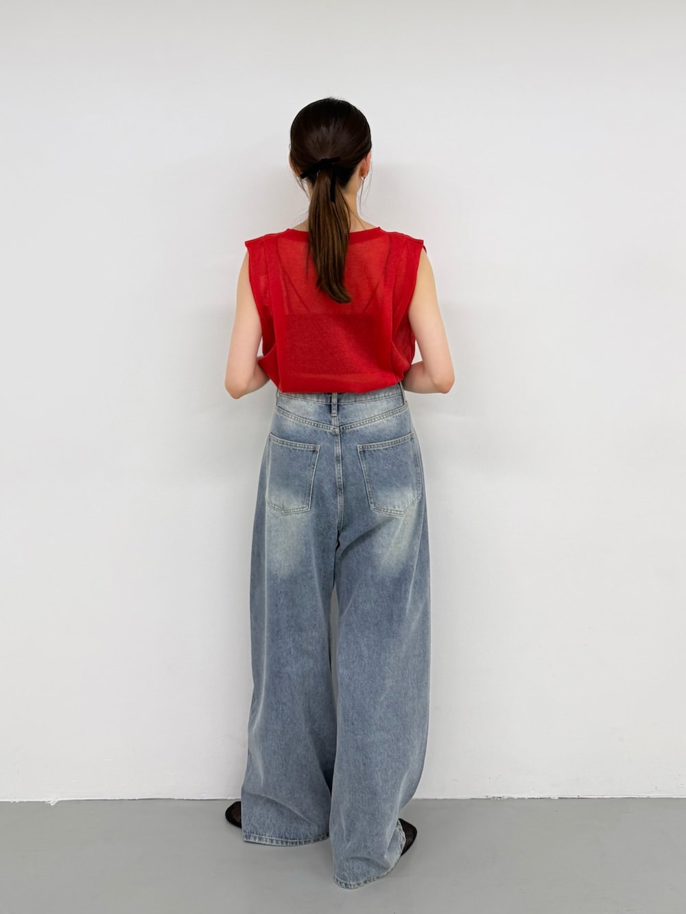 レッド系のニット/セーター、ブルー系のデニムパンツ、ブルー系のデニムパンツを着用したレディースの夏コーディネートの3枚目の写真