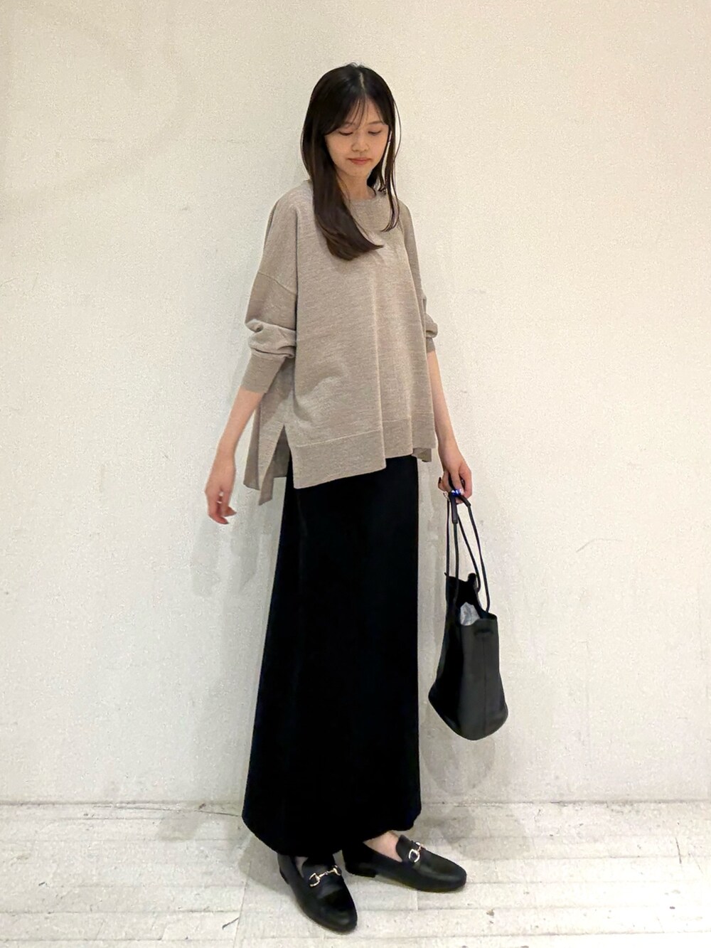 ベージュ系のニット/セーター、ベージュ系のニット/セーター、ブラック系のスカートを着用したレディースの秋コーディネートの4枚目の写真