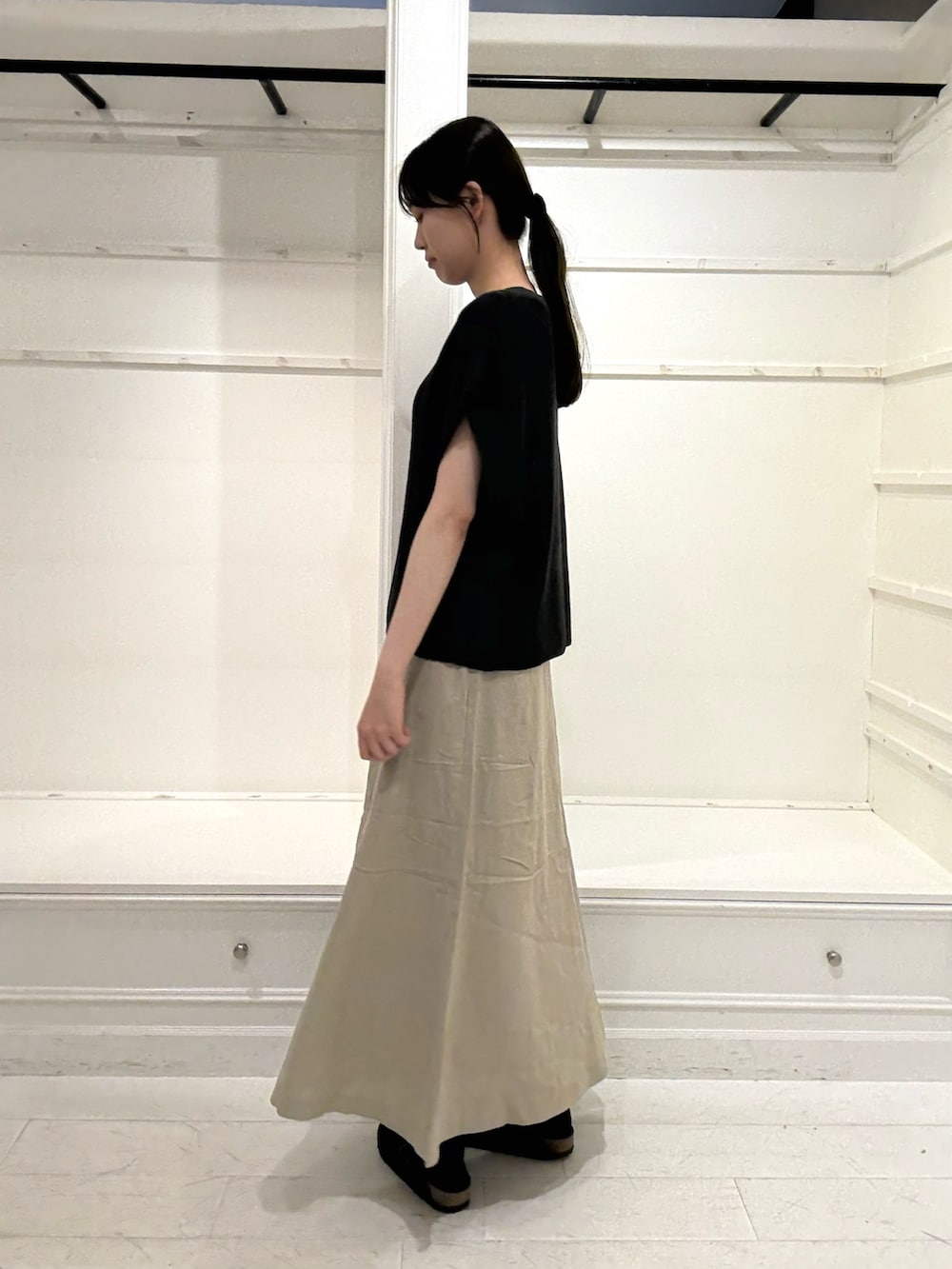 ブラウン系のハンドバッグ、グレー系のニット/セーター、ベージュ系のスカートを着用したレディースの夏コーディネートの3枚目の写真