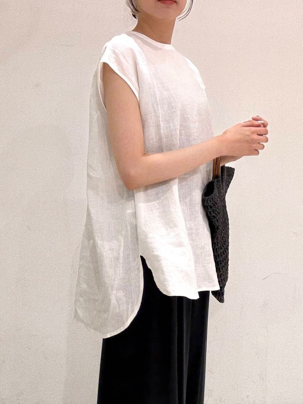 ブラック系のトートバッグ、ブラック系のバレエシューズ、ホワイト系のシャツ/ブラウスを着用したレディースの夏コーディネートの5枚目の写真