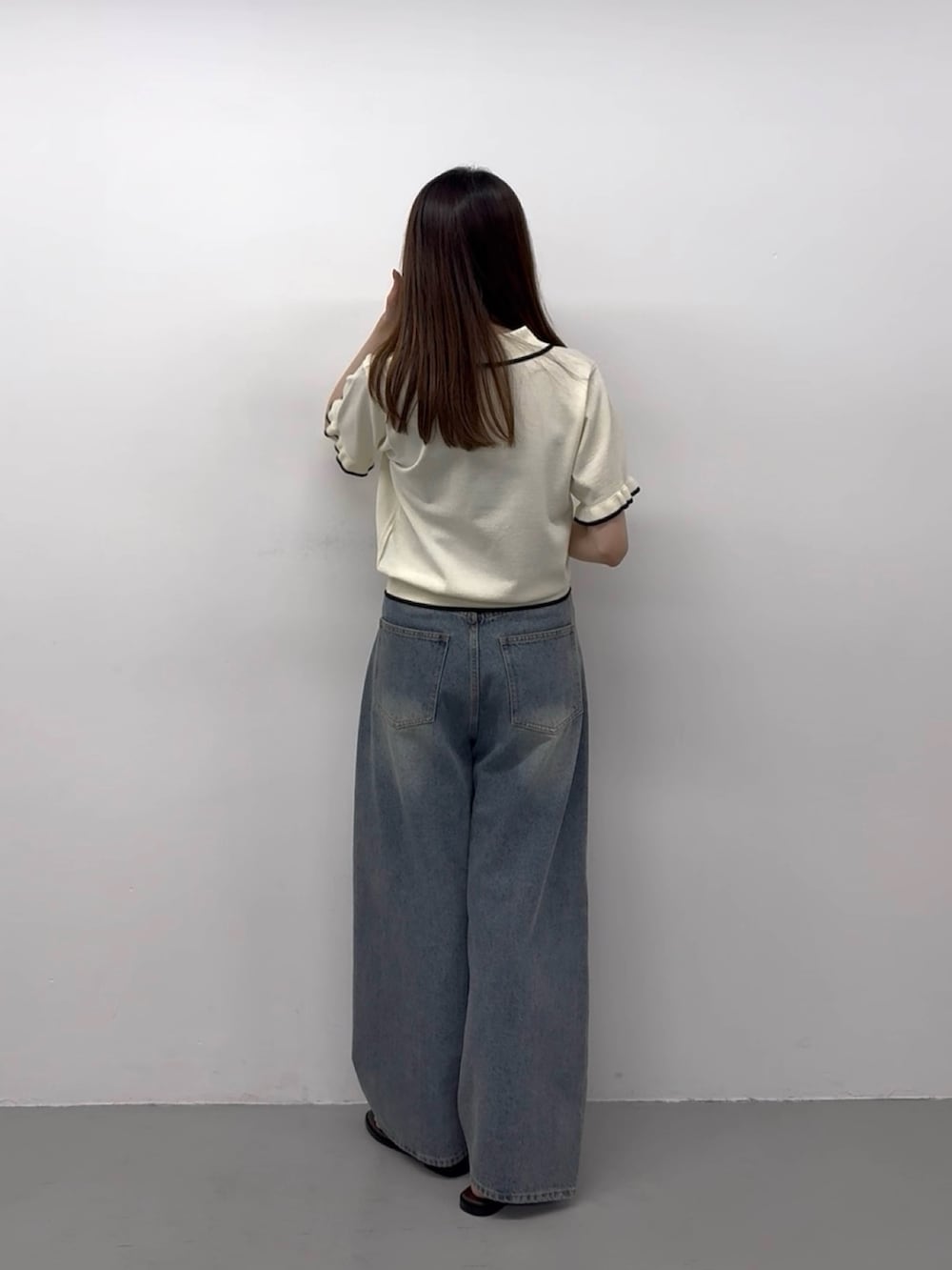 ホワイト系のニット/セーター、ブルー系のデニムパンツ、ブルー系のデニムパンツを着用したレディースの春コーディネートの2枚目の写真