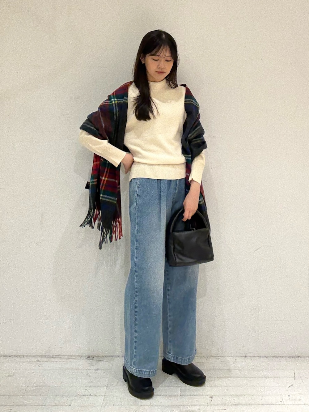 ホワイト系のニット/セーター、ホワイト系のニット/セーター、ブラック系のハンドバッグを着用したレディースの秋コーディネートの2枚目の写真