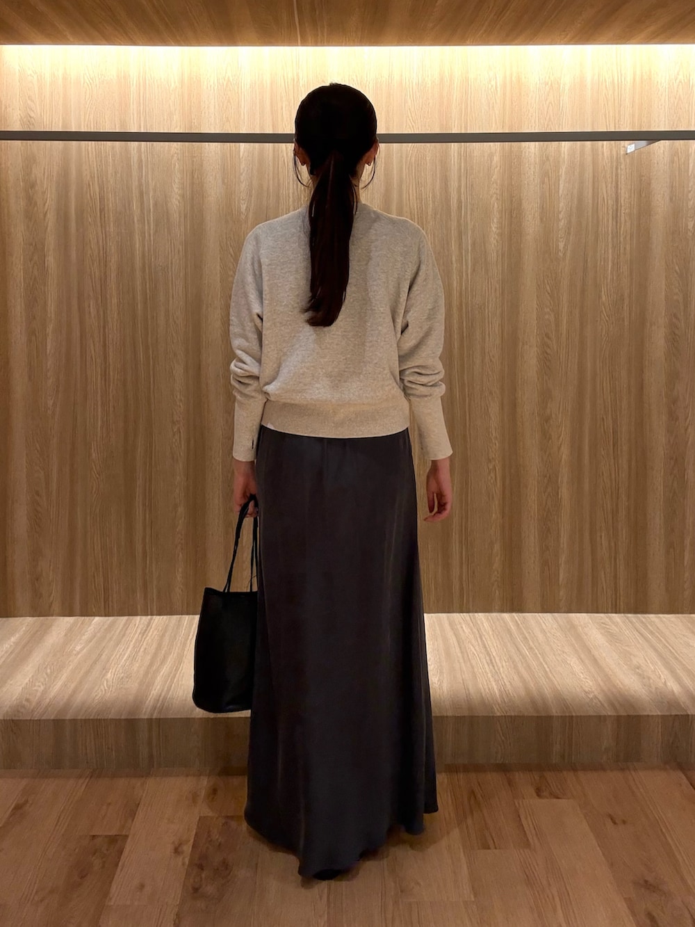 グレー系のTシャツ/カットソー、グレー系のスカート、ブラック系のショルダーバッグを着用したレディースの冬コーディネートの3枚目の写真