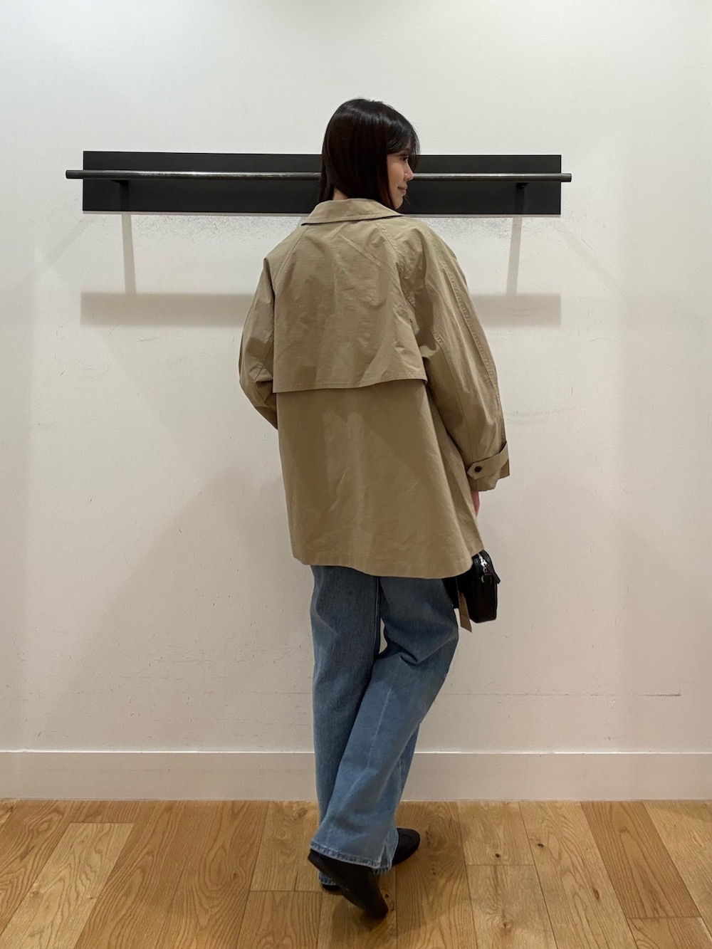 ベージュ系のステンカラーコート、ベージュ系のステンカラーコート、ブラック系のTシャツ/カットソーを着用したレディースの春コーディネートの3枚目の写真