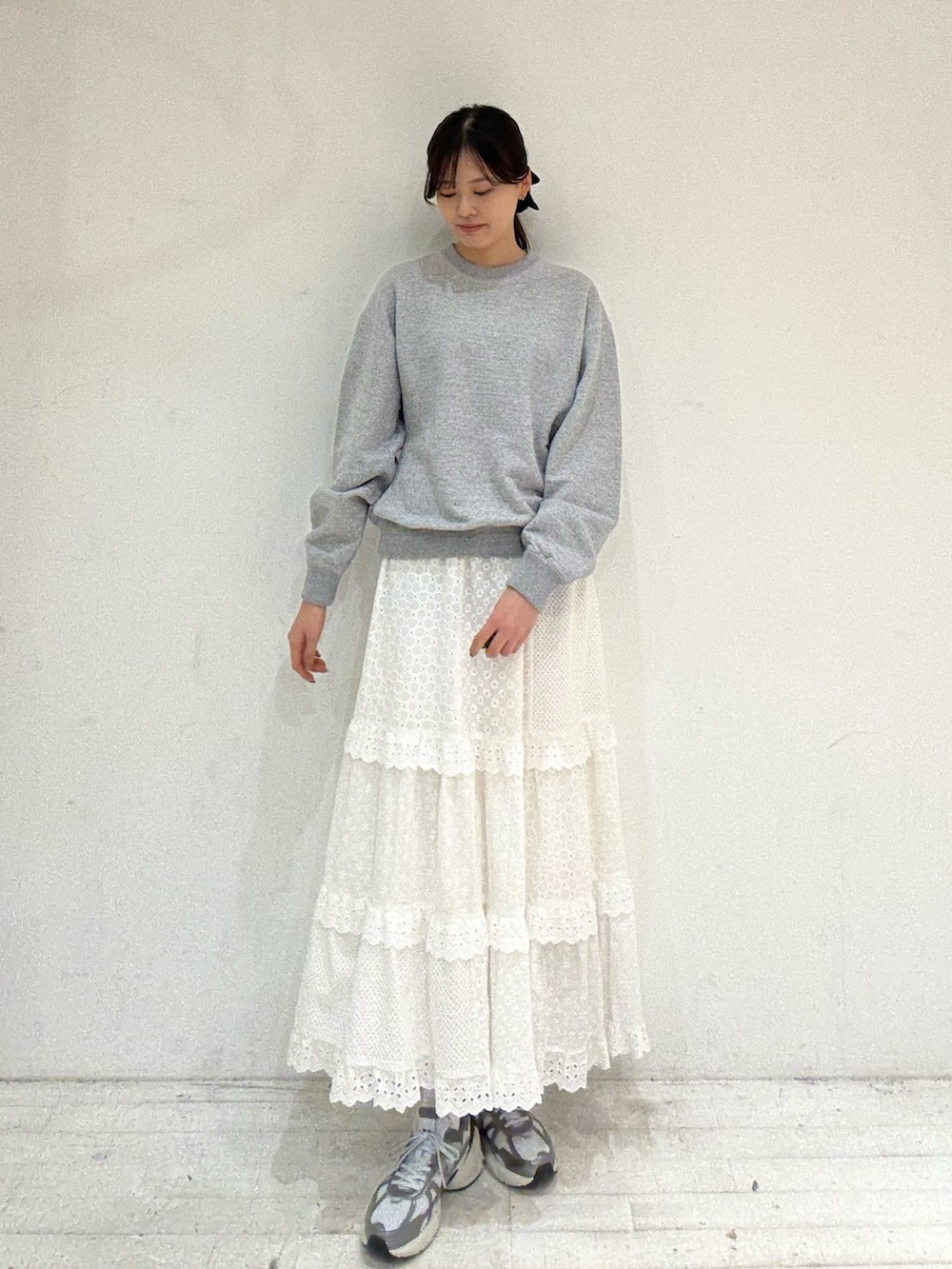 グレー系のスウェット、ホワイト系のスカート、ホワイト系のスカートを着用したレディースの秋コーディネートの2枚目の写真