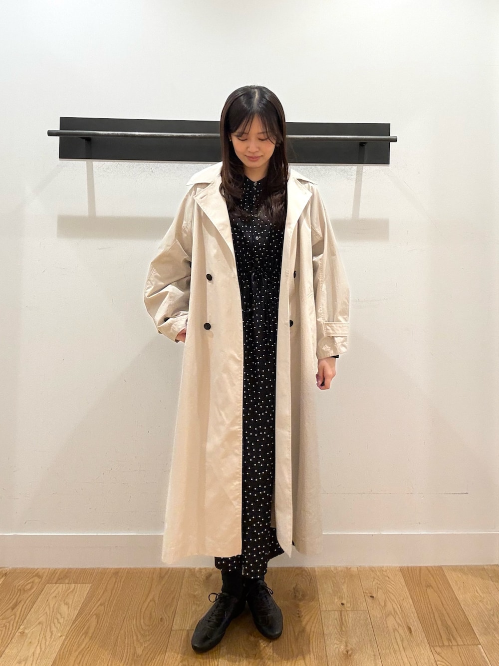 ベージュ系のトレンチコート、ベージュ系のトレンチコート、ブラック系のワンピースを着用したレディースの春コーディネートの2枚目の写真