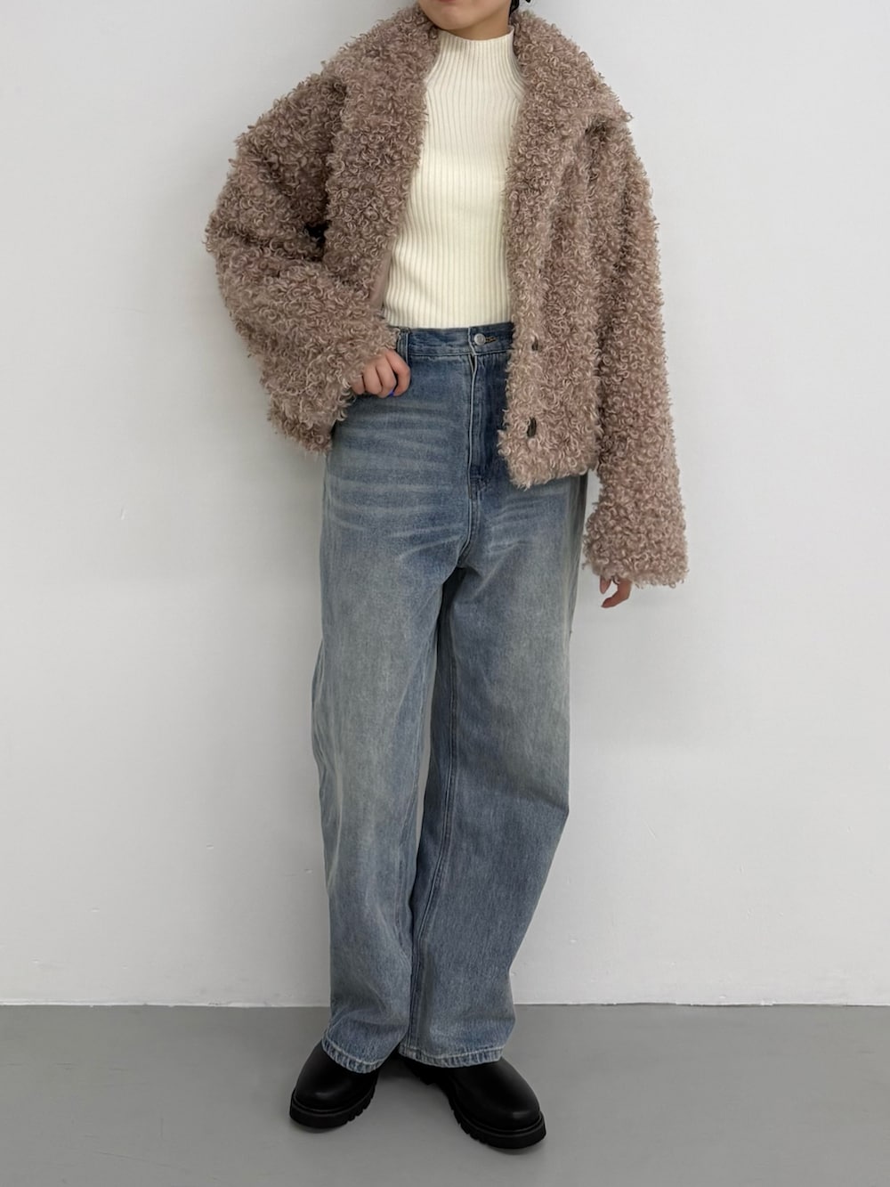 ホワイト系のニット/セーター、ホワイト系のニット/セーター、ブルー系のデニムパンツを着用したレディースの夏コーディネートの2枚目の写真