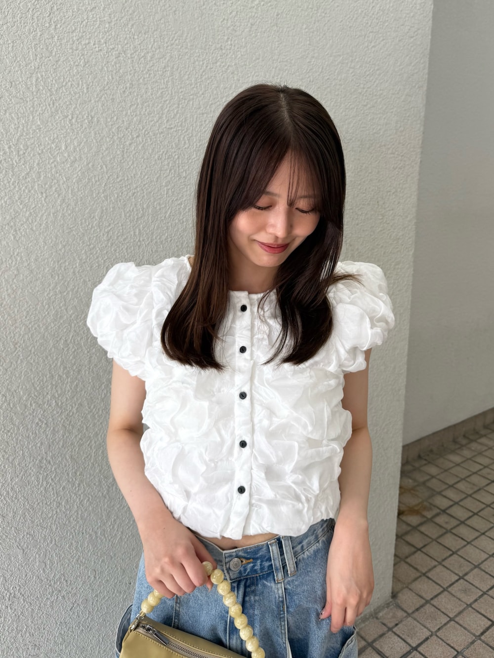 ホワイト系のシャツ/ブラウス、ホワイト系のシャツ/ブラウス、ベージュ系のショルダーバッグを着用したレディースの夏コーディネートの4枚目の写真