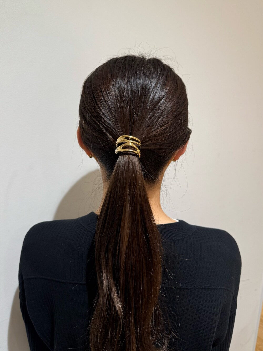 ゴールド系のヘアゴムを着用したレディースの冬コーディネートの2枚目の写真