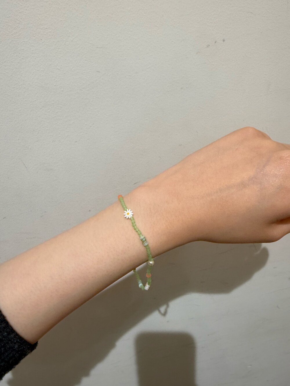 グリーン系のブレスレットを着用したレディースの春コーディネートの2枚目の写真