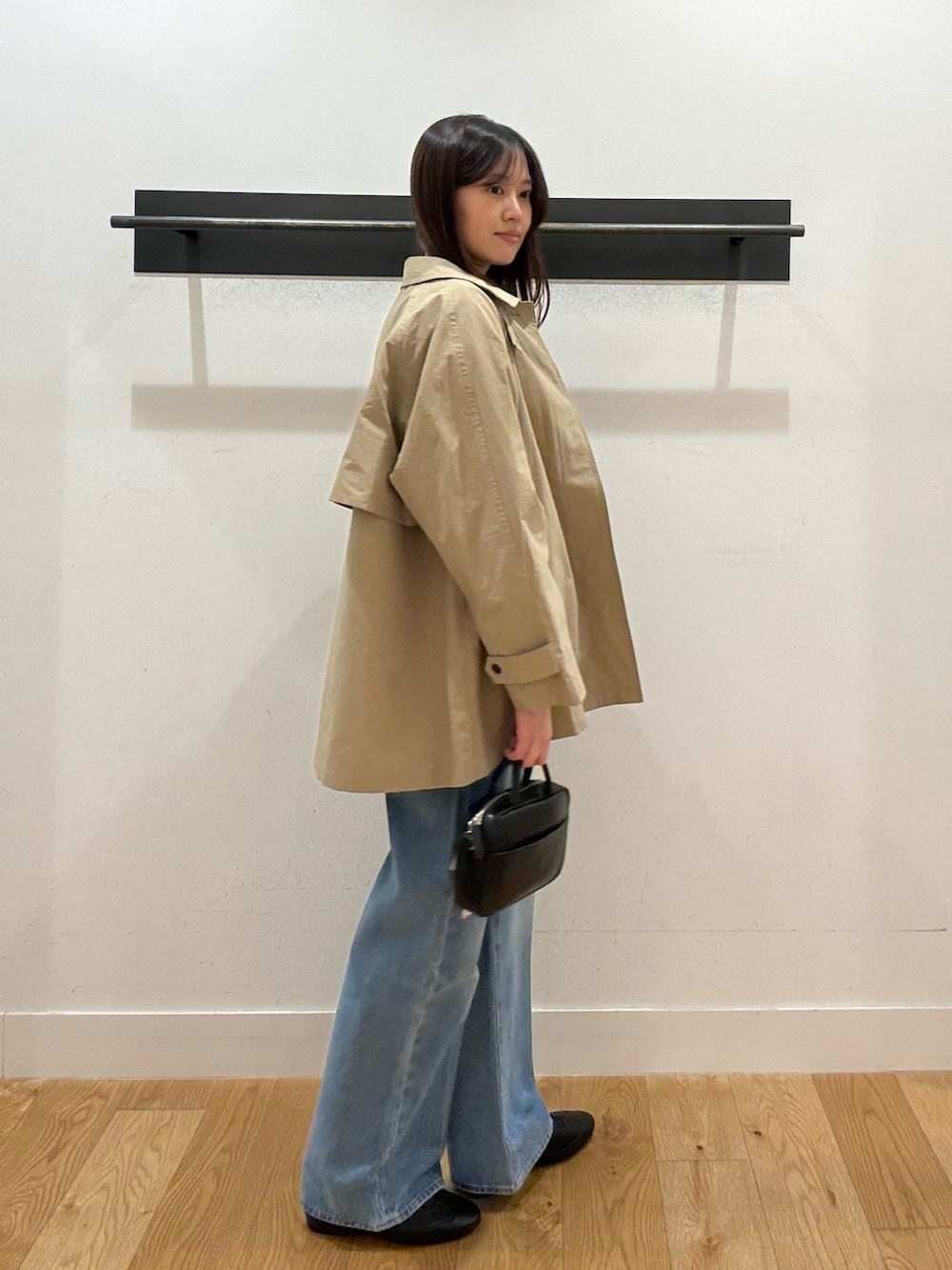 ベージュ系のステンカラーコート、ベージュ系のステンカラーコート、ブラック系のTシャツ/カットソーを着用したレディースの春コーディネートの2枚目の写真
