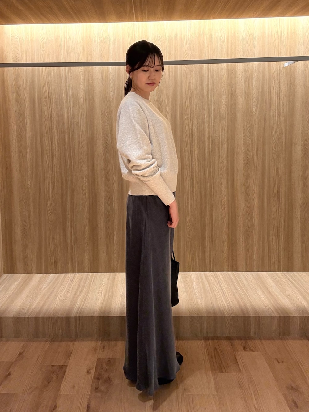 グレー系のTシャツ/カットソー、グレー系のスカート、ブラック系のショルダーバッグを着用したレディースの冬コーディネートの2枚目の写真