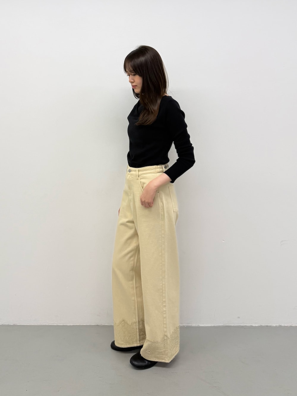 ブラック系のニット/セーター、ブラック系のニット/セーター、ベージュ系のデニムパンツを着用したレディースの秋コーディネートの2枚目の写真