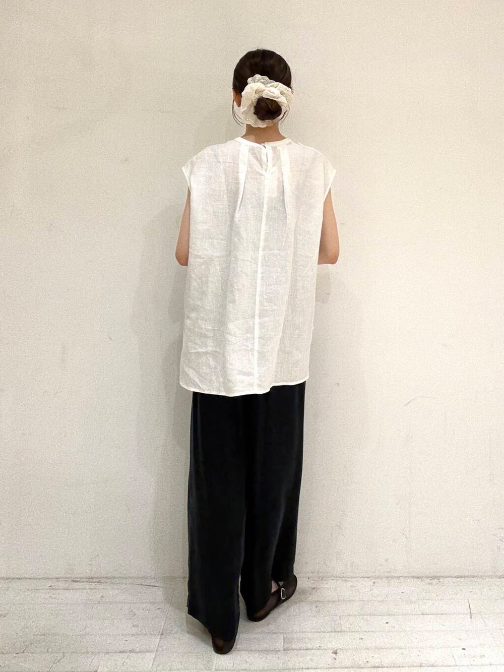 ブラック系のトートバッグ、ブラック系のバレエシューズ、ホワイト系のシャツ/ブラウスを着用したレディースの夏コーディネートの3枚目の写真