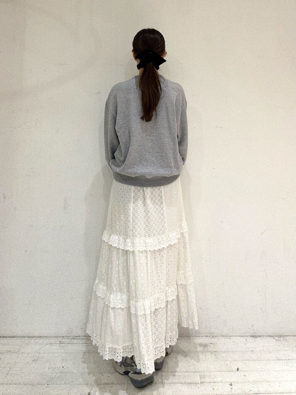 グレー系のスウェット、ホワイト系のスカート、ホワイト系のスカートを着用したレディースの秋コーディネートの3枚目の写真