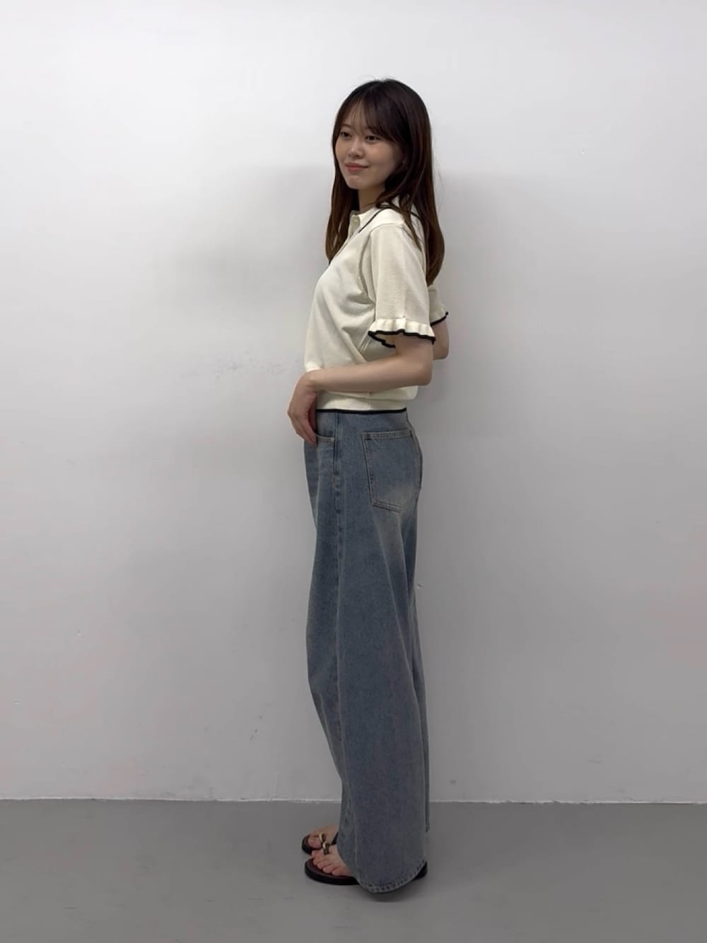 ホワイト系のニット/セーター、ブルー系のデニムパンツ、ブルー系のデニムパンツを着用したレディースの春コーディネートの3枚目の写真