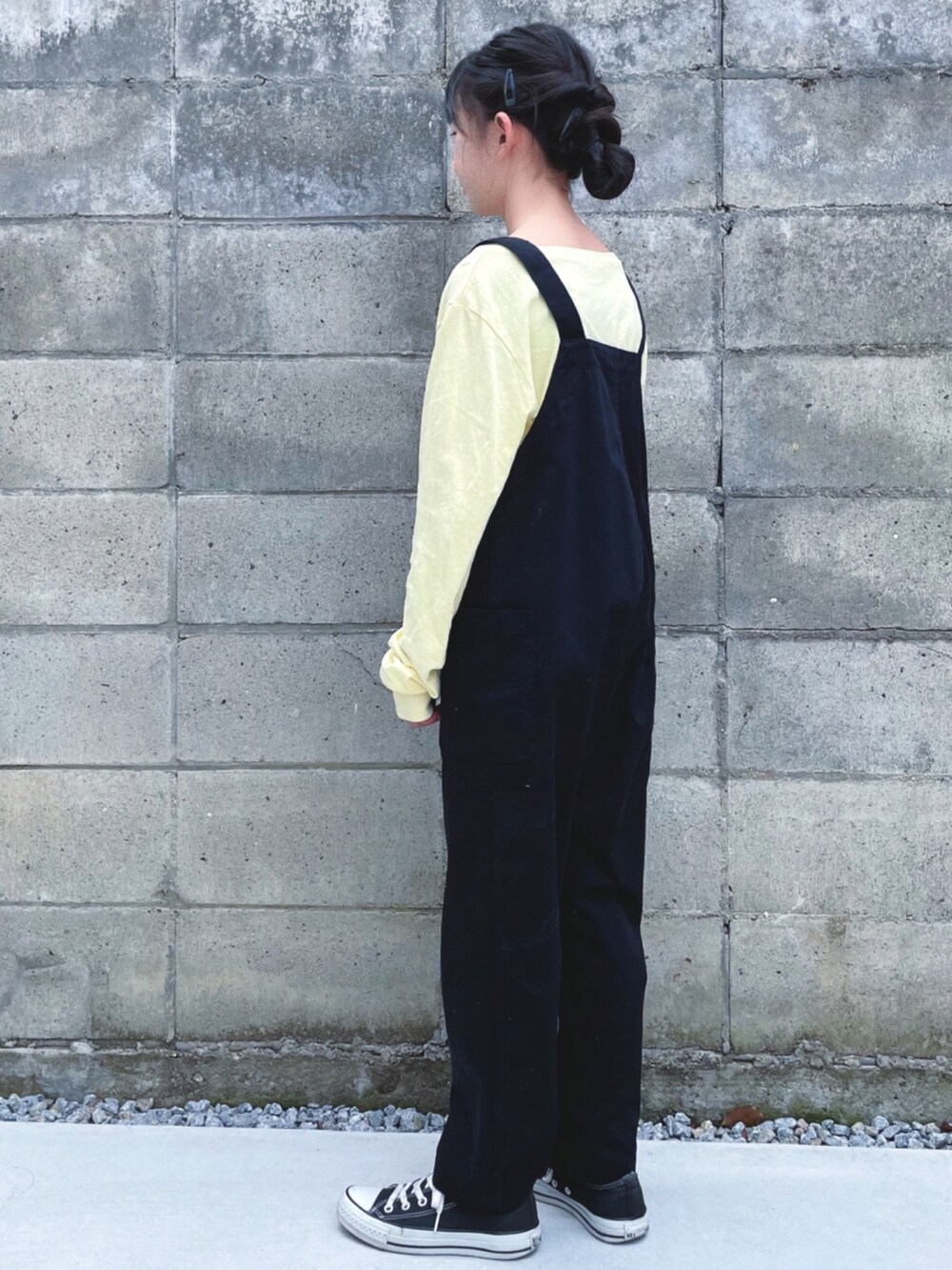 イエロー系のTシャツ/カットソー、ブラック系のサロペット/オーバーオール、ブラック系のスニーカーを着用したキッズの春コーディネートの2枚目の写真