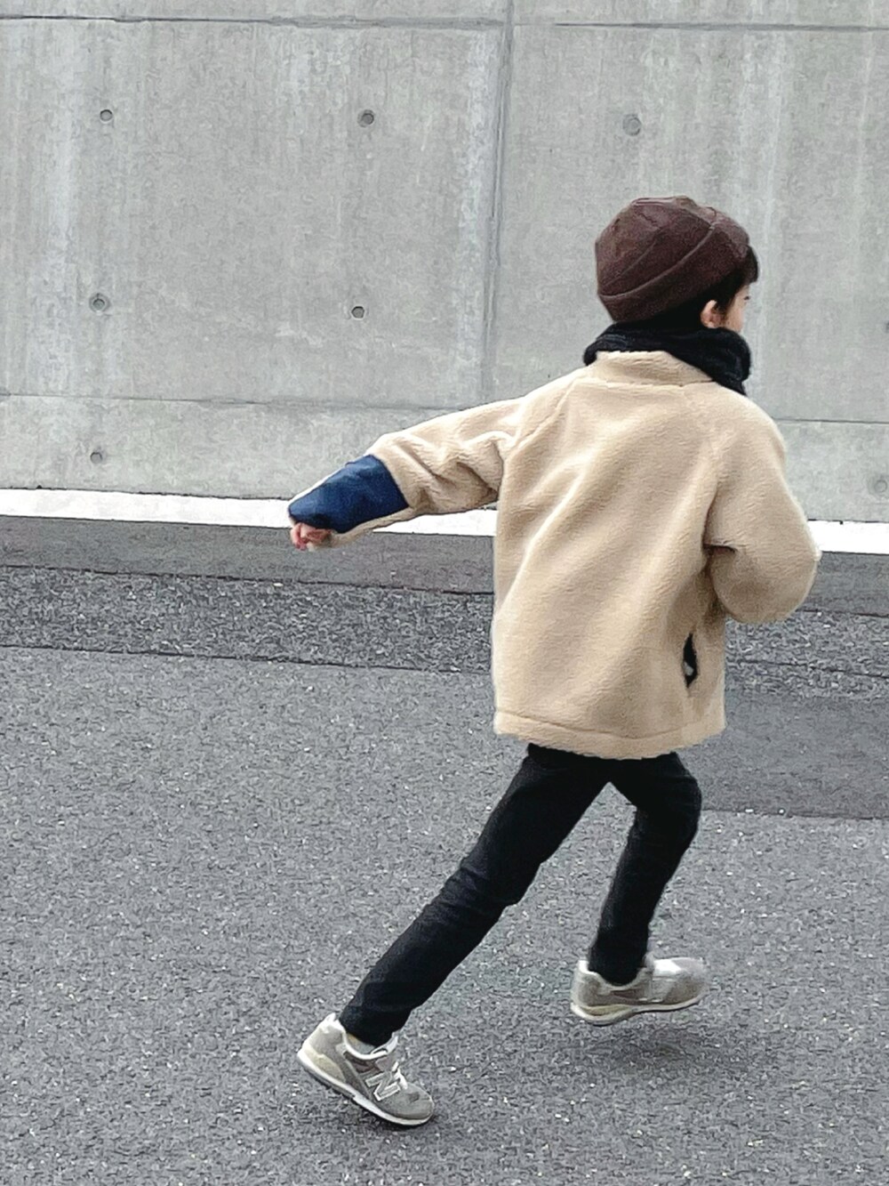 ベージュ系のブルゾン、ブラック系のその他パンツ、グレー系のスニーカーを着用したキッズの冬コーディネートの2枚目の写真