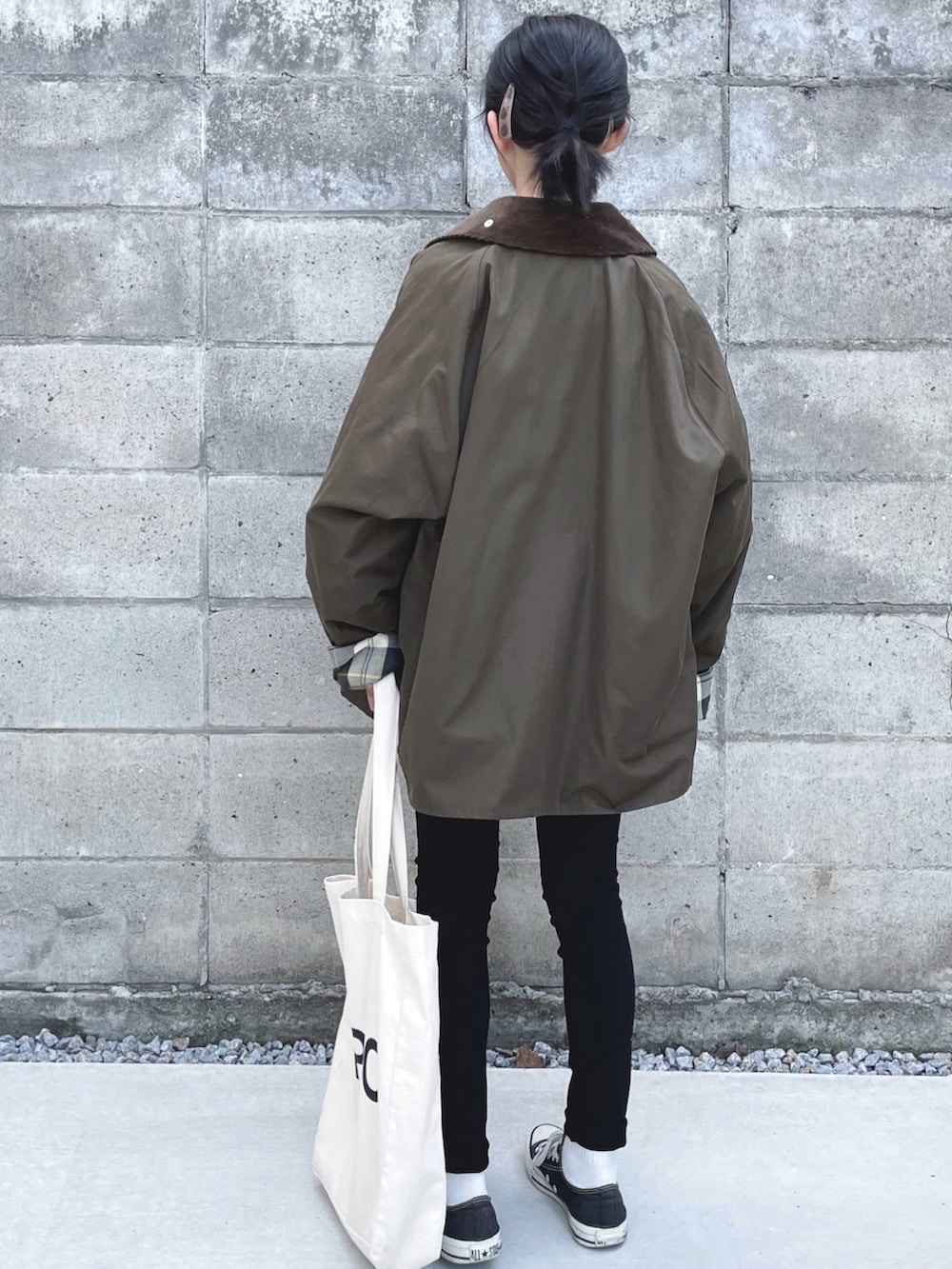 グリーン系のブルゾン、ブラック系のスニーカー、ホワイト系のトートバッグを着用したキッズの秋コーディネートの2枚目の写真