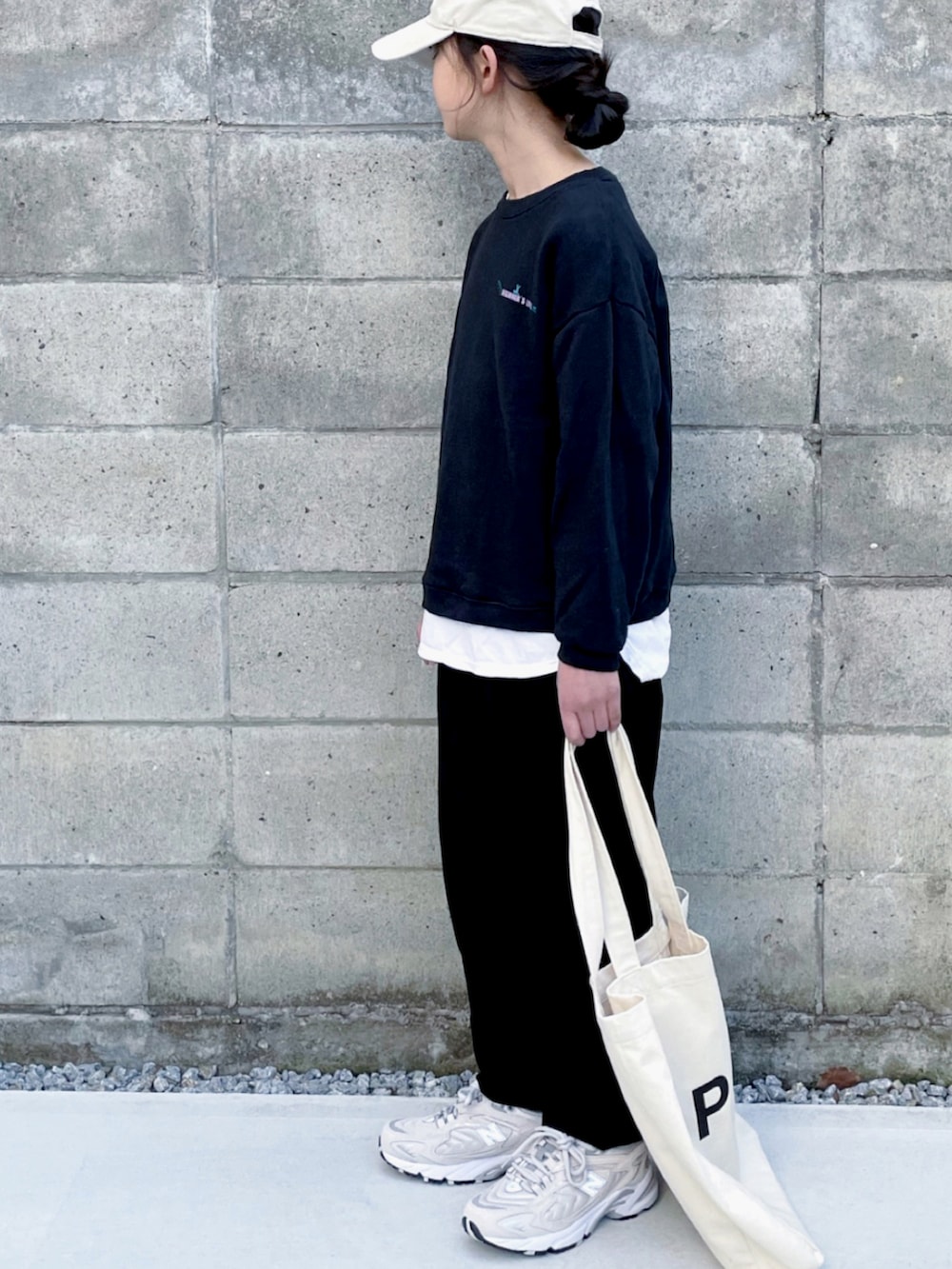 ベージュ系のスニーカー、ブラック系のその他パンツ、ホワイト系のトートバッグを着用したキッズの冬コーディネートの2枚目の写真