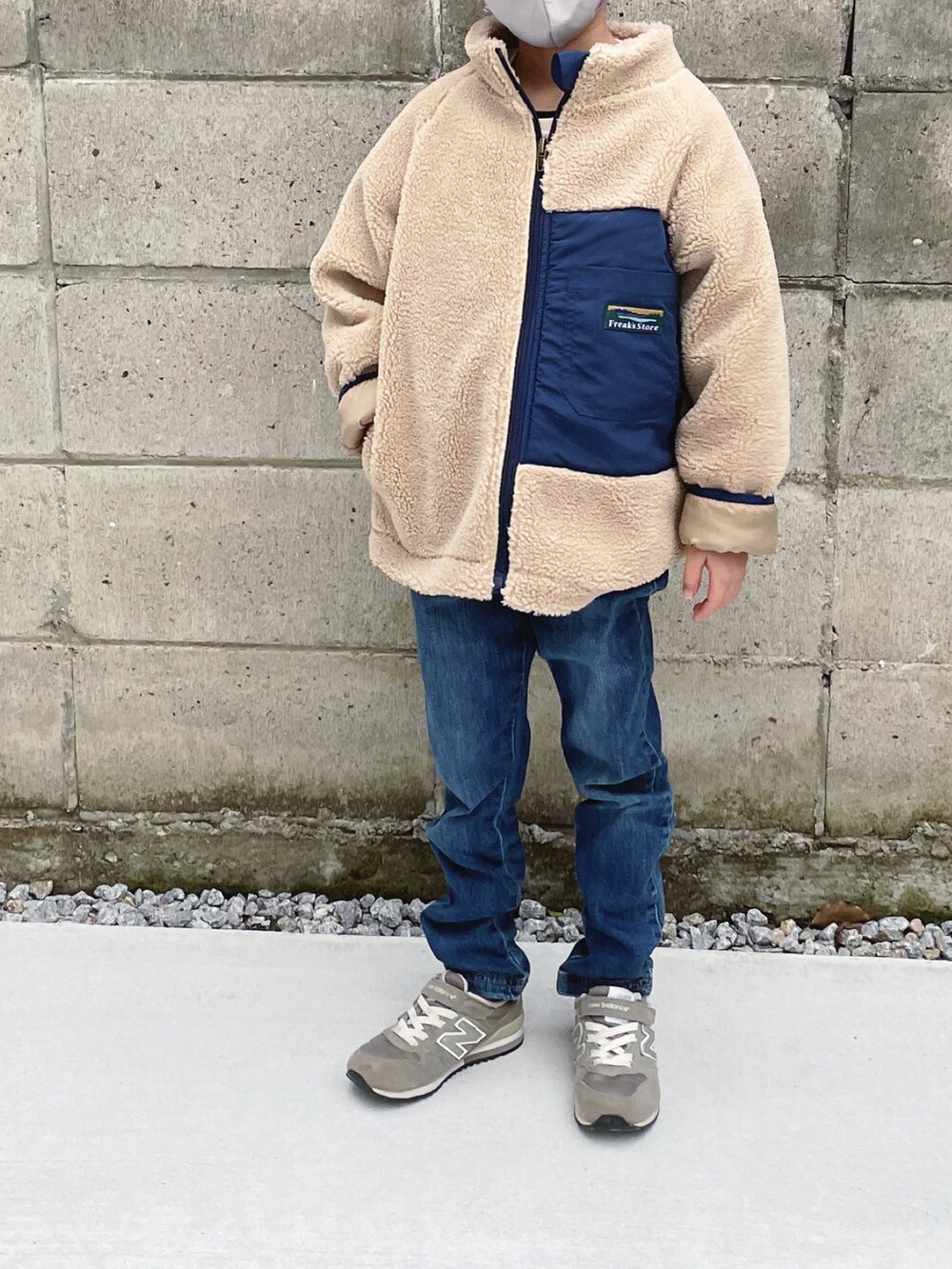 ベージュ系のブルゾン、グレー系のスニーカー、グレー系のマスクを着用したキッズの冬コーディネートの2枚目の写真