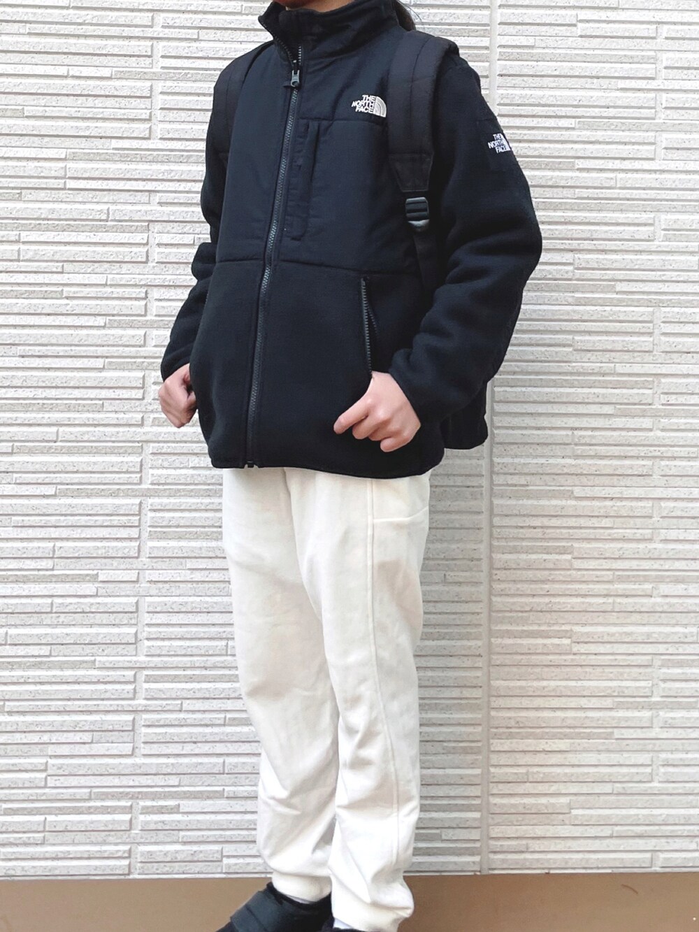 ブラック系のブルゾン、ホワイト系のスウェットパンツ、ブラック系のスニーカーを着用したキッズの冬コーディネートの3枚目の写真