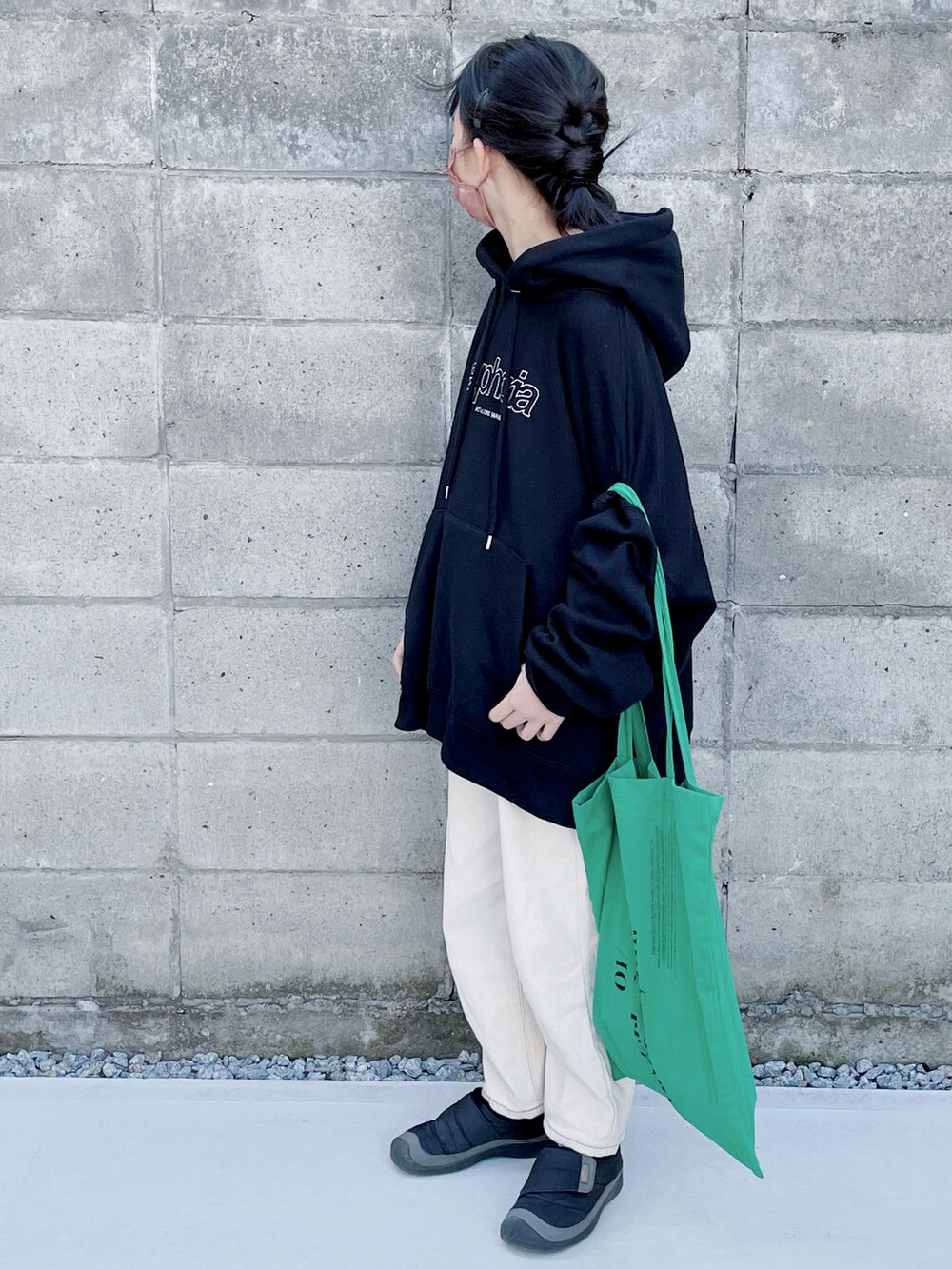 グリーン系のエコバッグ/サブバッグ、ブラック系のパーカー、ベージュ系のデニムパンツを着用したキッズの冬コーディネートの2枚目の写真