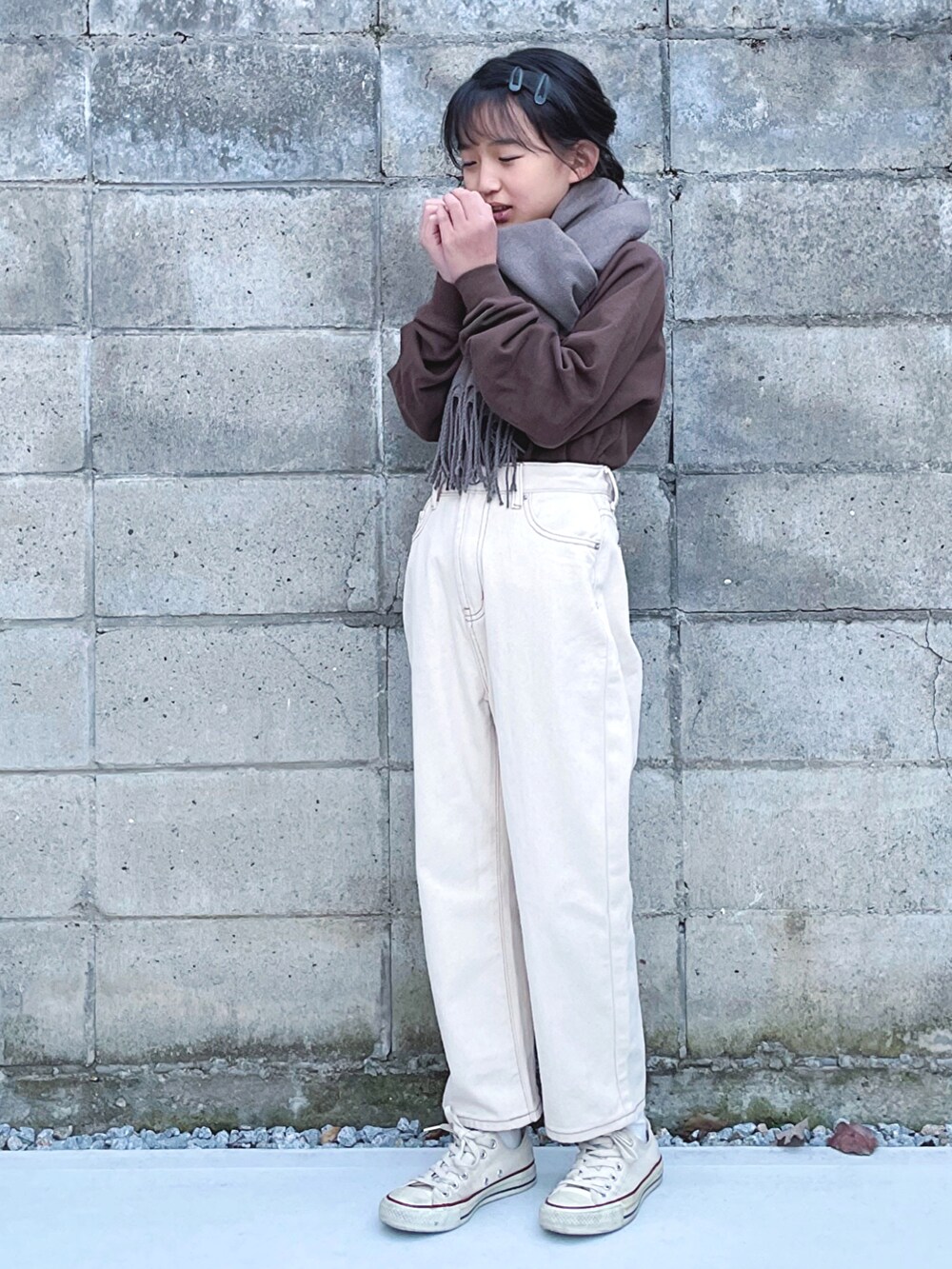 ベージュ系のデニムパンツ、ホワイト系のスニーカー、ブラウン系のスウェットを着用したキッズの秋コーディネートの2枚目の写真