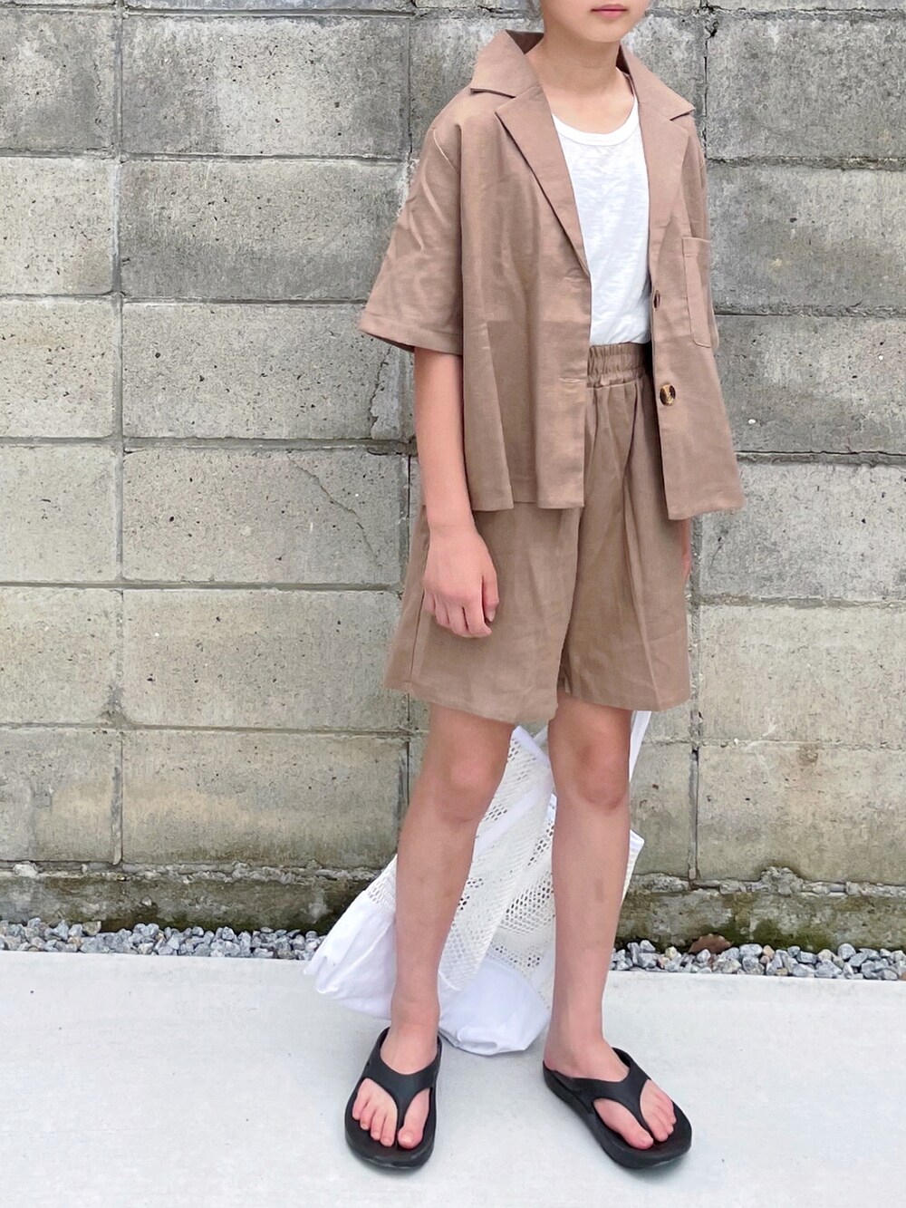 ブラウン系のセットアップ、ホワイト系のタンクトップ、ブラック系のサンダルを着用したキッズの夏コーディネートの2枚目の写真