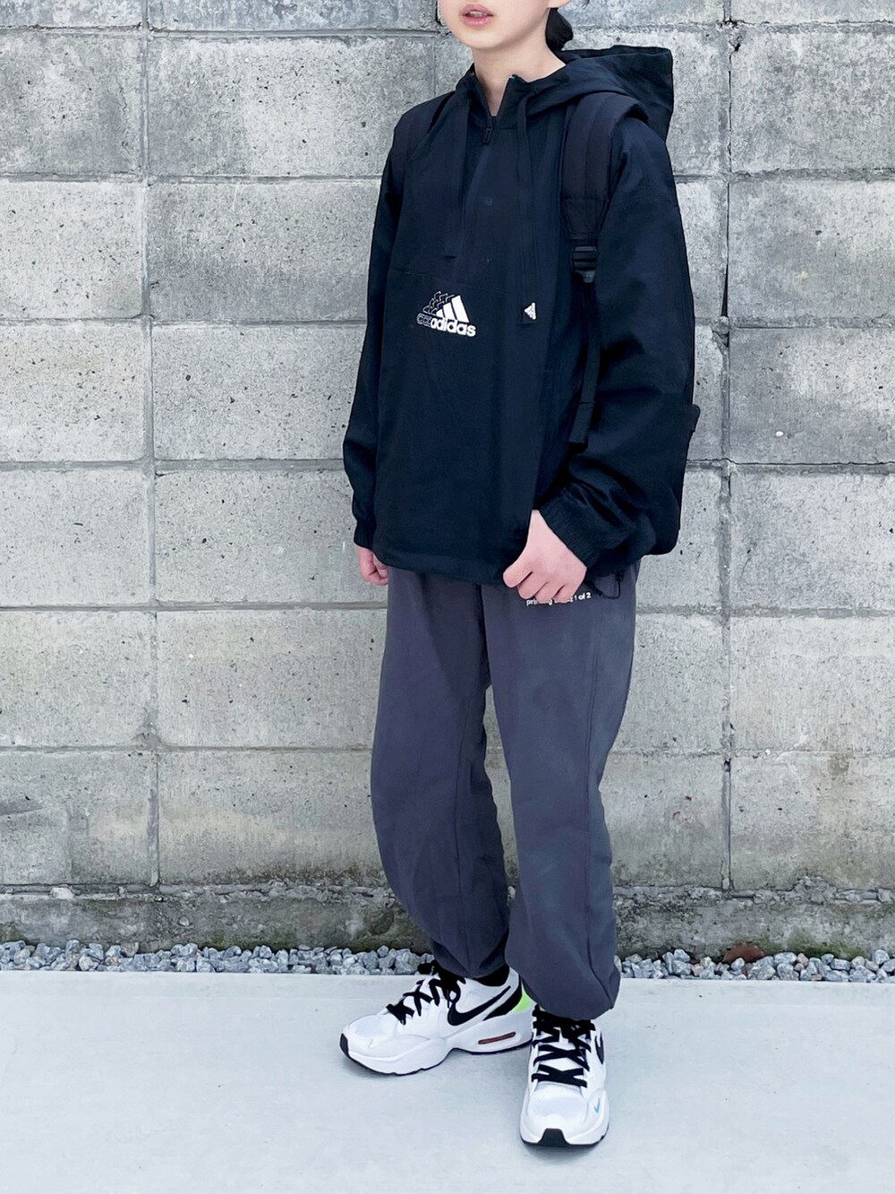 ブラック系のナイロンジャケット、グレー系のスウェットパンツ、ホワイト系のスニーカーを着用したキッズの春コーディネートの2枚目の写真