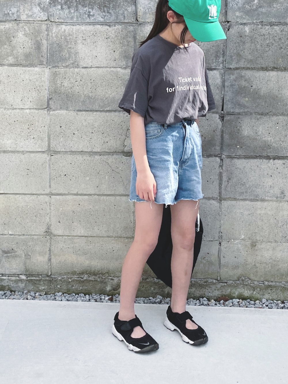 ブルー系のデニムパンツ、ブラック系のショルダーバッグ、ブラック系のスニーカーを着用したキッズの春コーディネートの2枚目の写真