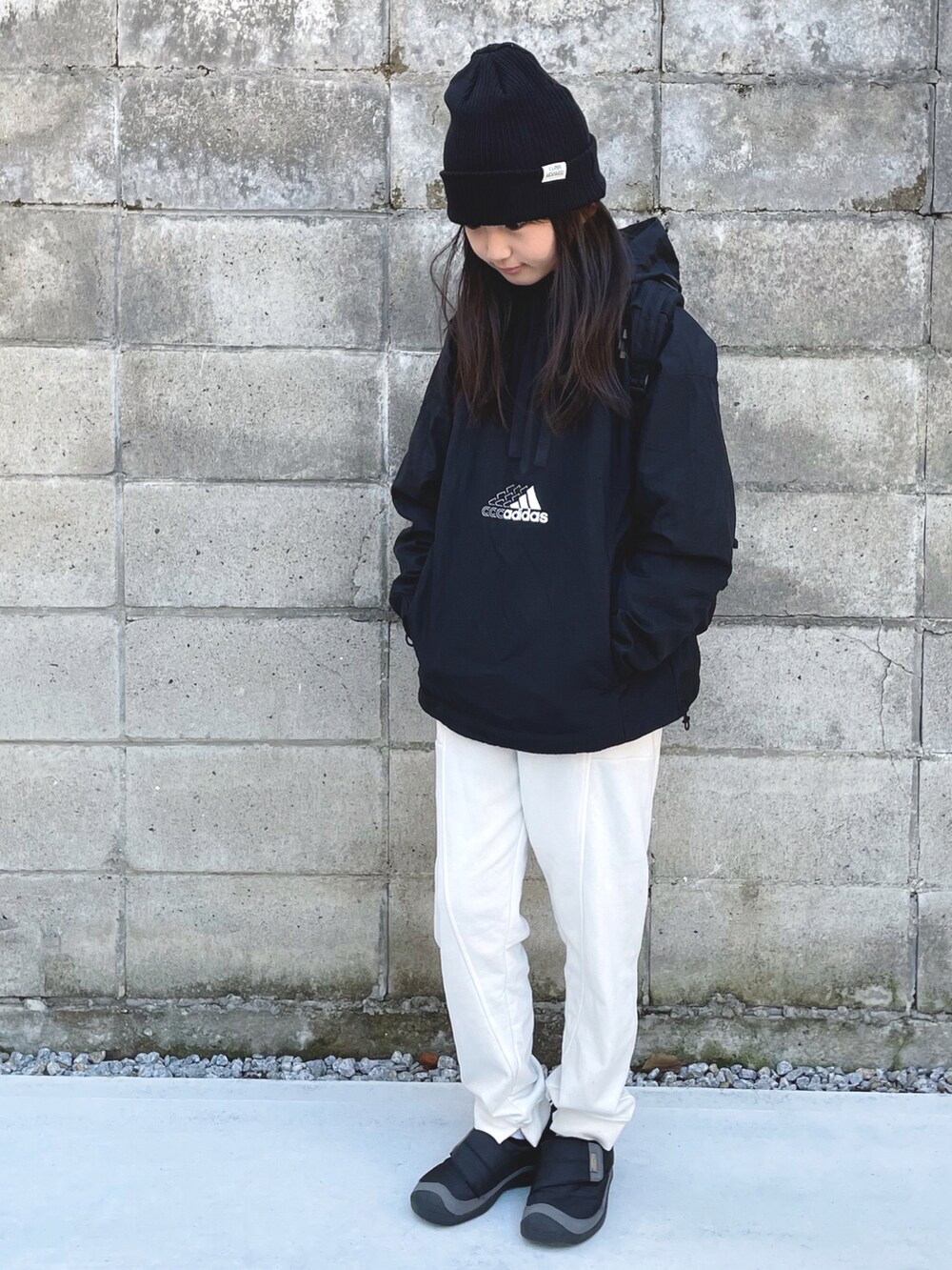 ブラック系のナイロンジャケット、ホワイト系のスウェットパンツ、ブラック系のスニーカーを着用したキッズの冬コーディネートの3枚目の写真