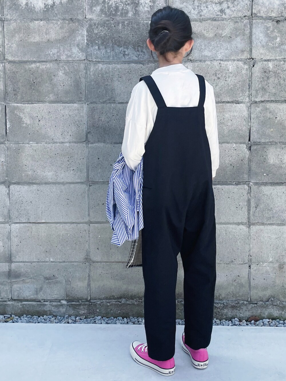 ピンク系のスニーカー、ブルー系のシャツ/ブラウス、ブラック系のサロペット/オーバーオールを着用したキッズの春コーディネートの2枚目の写真